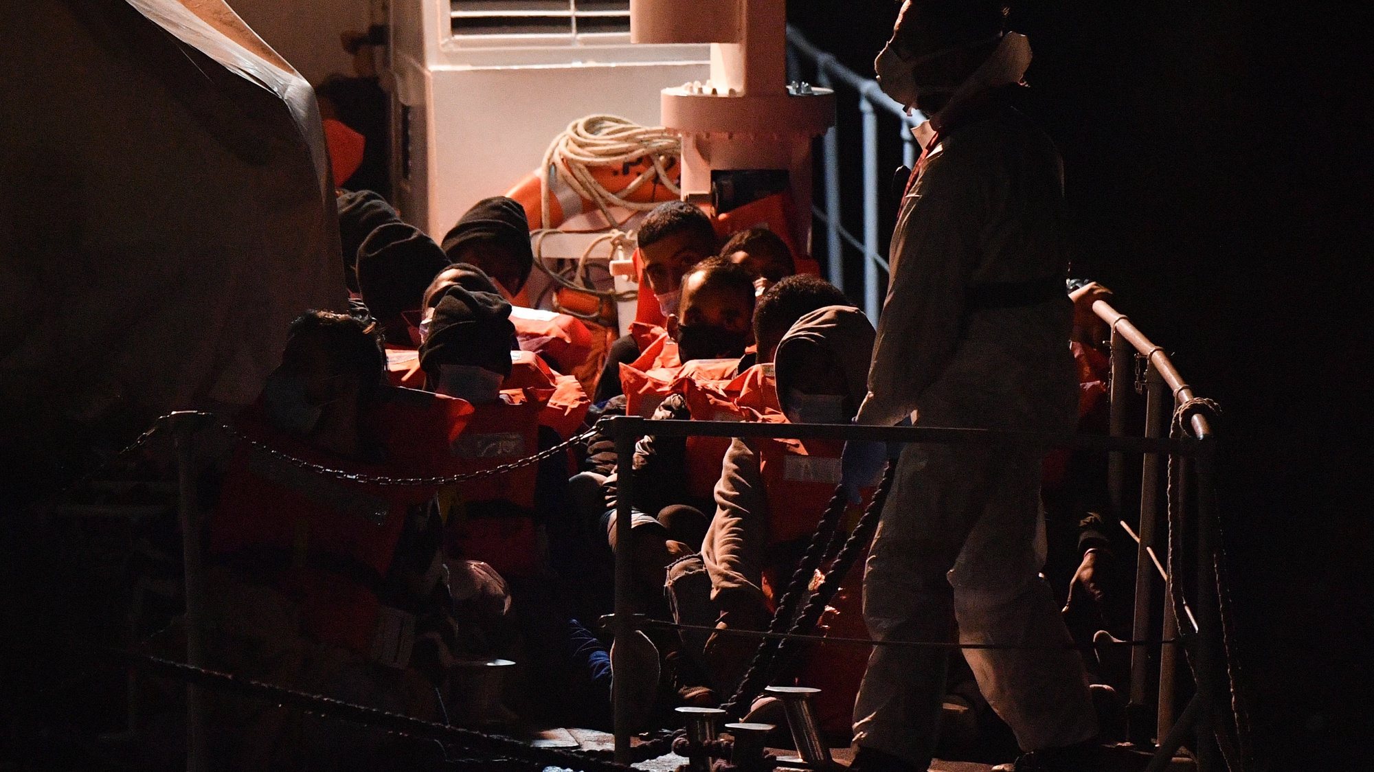 epa09592342 Migrants onboard the Geo Barents ship managed by the NGO Doctors Without Borders prepare to disembark in the harbor of Messina, Sicily, Italy, 19 November 2021. A total of 186 migrants were rescued in the Mediterranean Sea. Ten bodies were also recovered.  EPA/CARMELO IMBESI