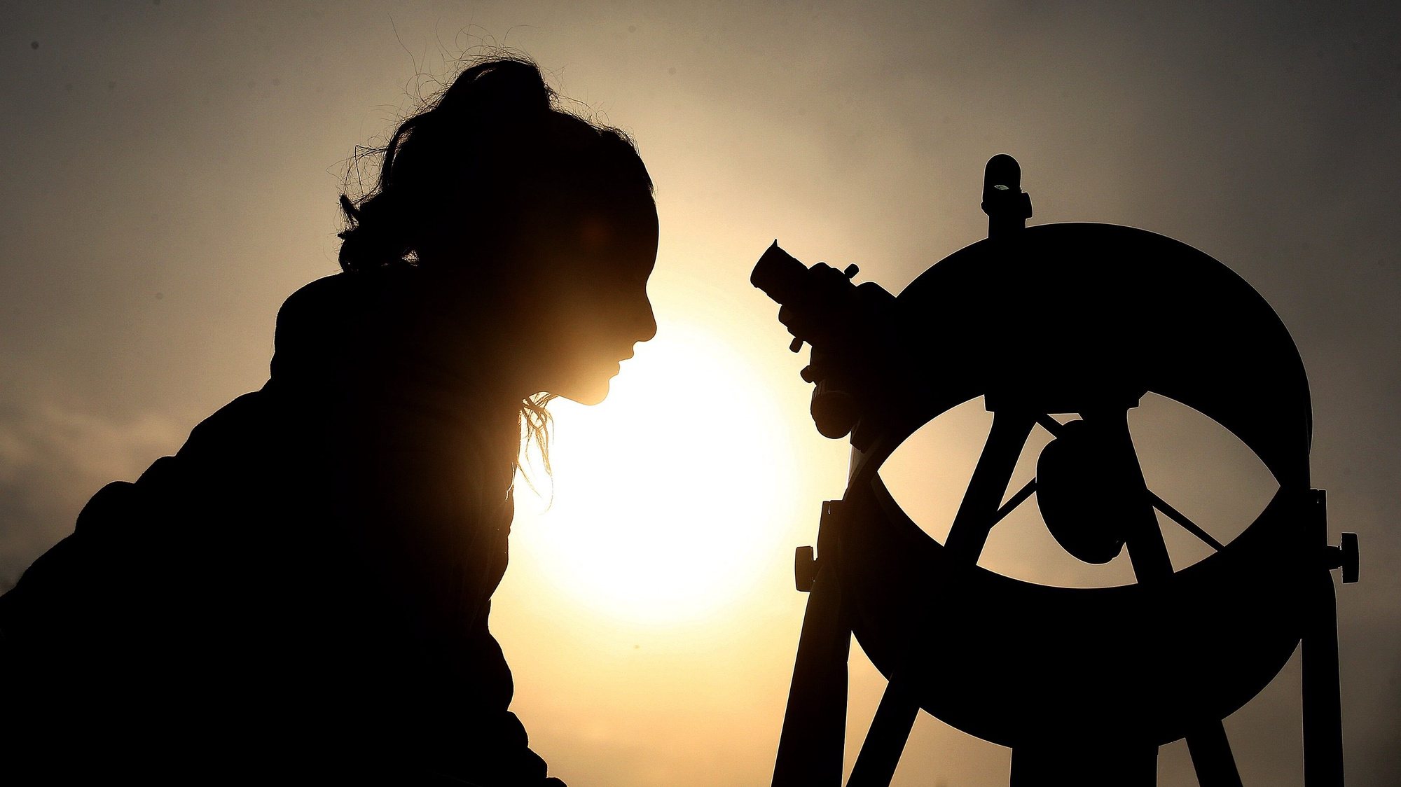 epaselect epa05598701 A woman looks through a solar telescope during an astronomical observation at the Chilean Skies Observatory, in Santiago de Chile, Chile, 22 October 2016. Thirty people participated in a daytime astronomical observation with a dozen telescopes that allowed them to see the sun, planets such as Venus, Mars and Saturn and some stars.  EPA/ELVIS GONZALEZ
