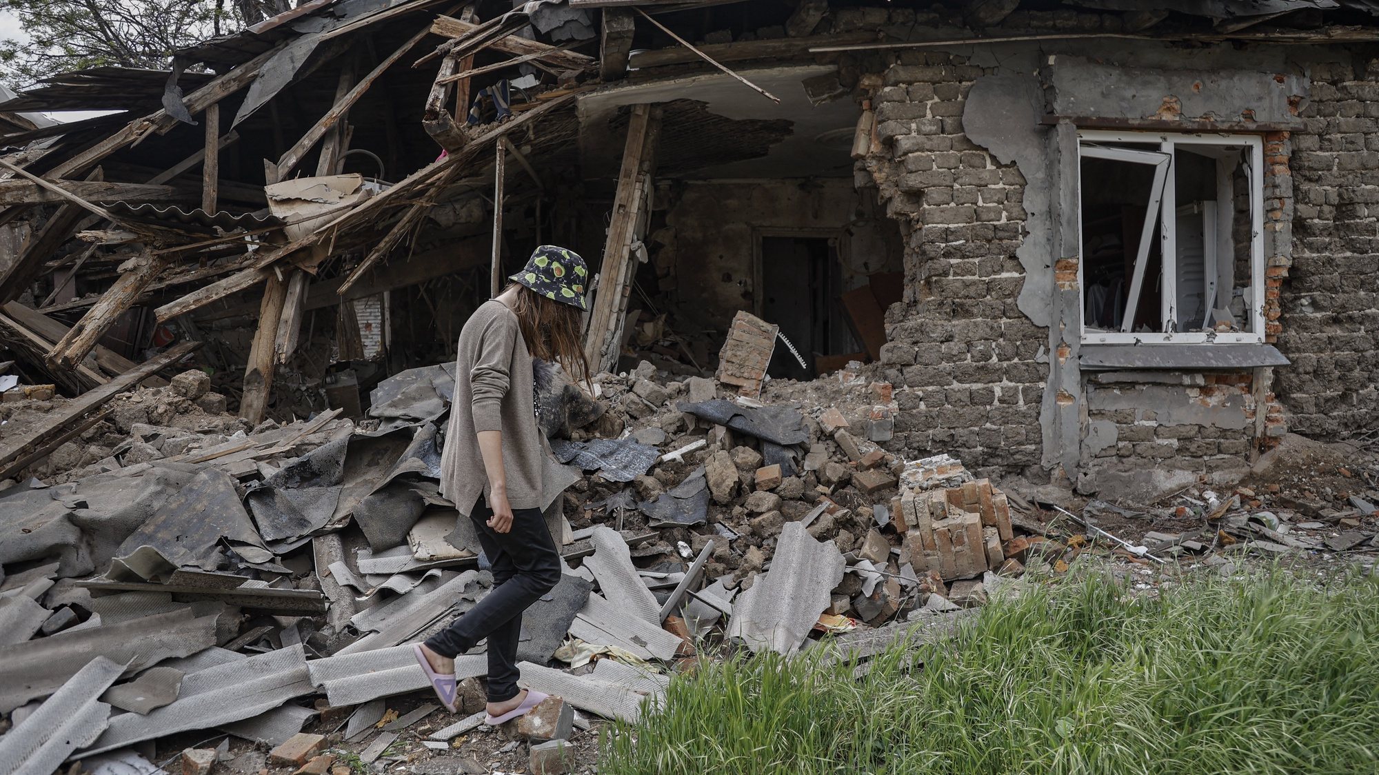 epa09965027 A woman walks past her destroyed house in Mariupol, Ukraine, 21 May 2022 (issued 22 May 2022). According to the Head of the self-proclaimed Donetsk People&#039;s Republic Denis Pushilin, 60 percent of the houses in Mariupol were destroyed, 20 percent of which cannot be rebuilt. The Chief spokesman of the Russian Defense Ministry, Major General Igor Konashenkov, said on 20 May that the long-besieged Azovstal steel plant in Mariupol was under full Russian army control.  EPA/ALESSANDRO GUERRA
