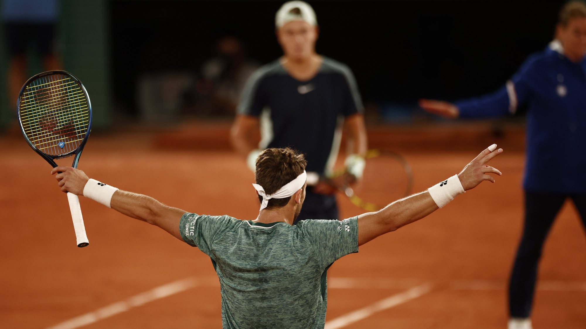 epa09990874 Casper Ruud (foreground) of Norway reacts after winning against Holger Rune (background) of Denmark in their men’s quarterfinal match during the French Open tennis tournament at Roland ​Garros in Paris, France, 01 June 2022.  EPA/YOAN VALAT