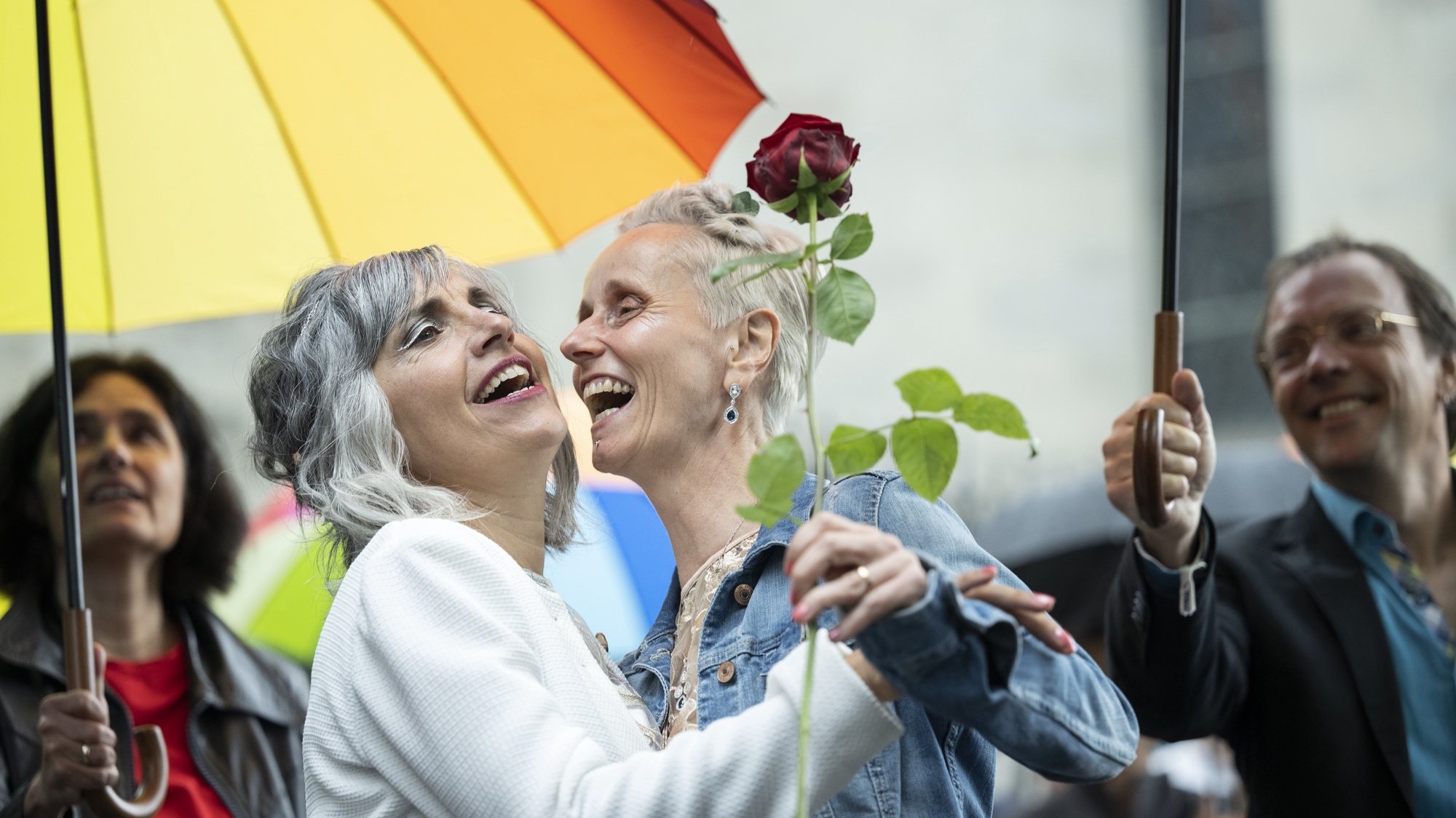 epa10045216 Annett Babinsky (C) and Laura Suarez (2-L) embrace after marrying at the registry office in Zurich, Switzerland, 01 July 2022. Following a referendum in fall 2021 that ended in favor of a &#039;Marriage For All&#039;, same sex couples since 01 July 2022 for the first time are allowed to officially marry in Switzerland.  EPA/ENNIO LEANZA