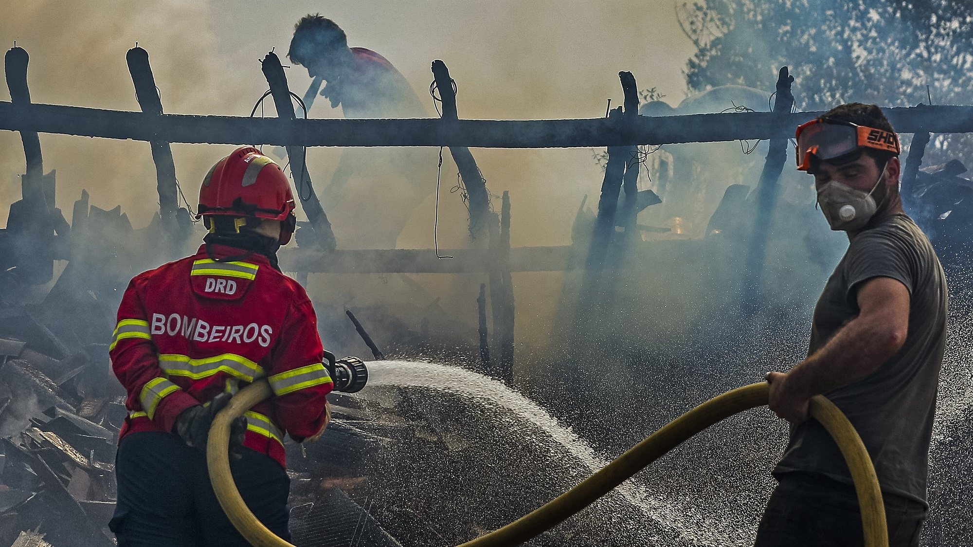 Bombeiros combatem o fogo que destruiu um barracão de lenha junto a uma casa em Macieira, durante o incêndio que começou em Abiul, Pombal, na passada sexta-feira, Macieira, Alvaiázere, 14 de julho de 2022. PAULO NOVAIS/LUSA