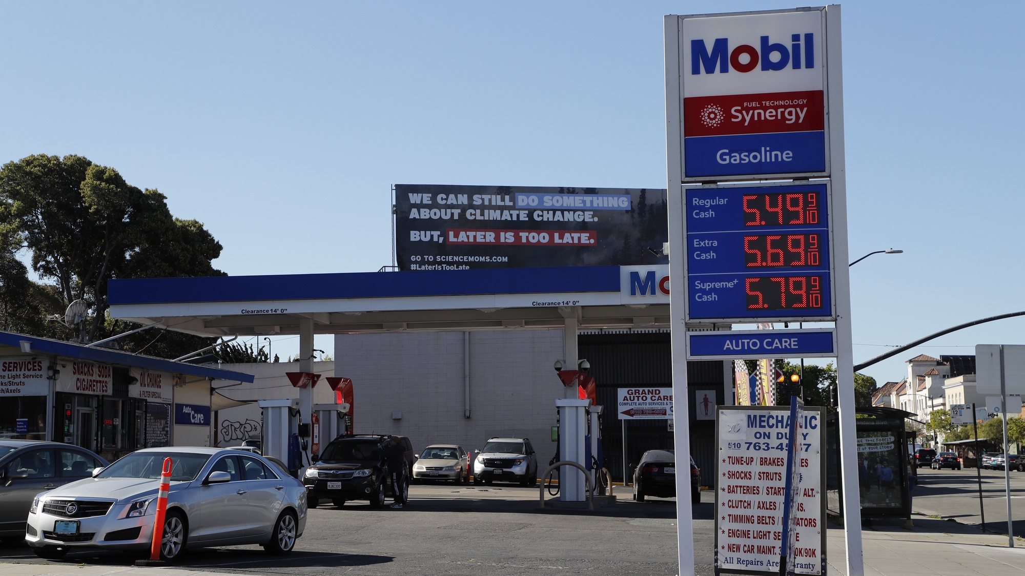 epa09808248 An Exxon-Mobil gasoline station price sign and a climate change billboard in the background in Oakland, California, USA, 07 March 2022. With the state of California being the highest in the country, the US national average for a gallon of gasoline is at four US dollars per gallon as of 07 March, a 40 cent per gallon increase in the last week, as oil prices hit 13-year highs as a result of the expected impact of the sanctions being imposed on Russia after its invasion of Ukraine. The US Department of Energy (DOE) has approved a twelfth exchange of 2.7 million barrels of crude oil for release to ExxonMobil from the Strategic Petroleum Reserve (SPR).  EPA/JOHN G. MABANGLO