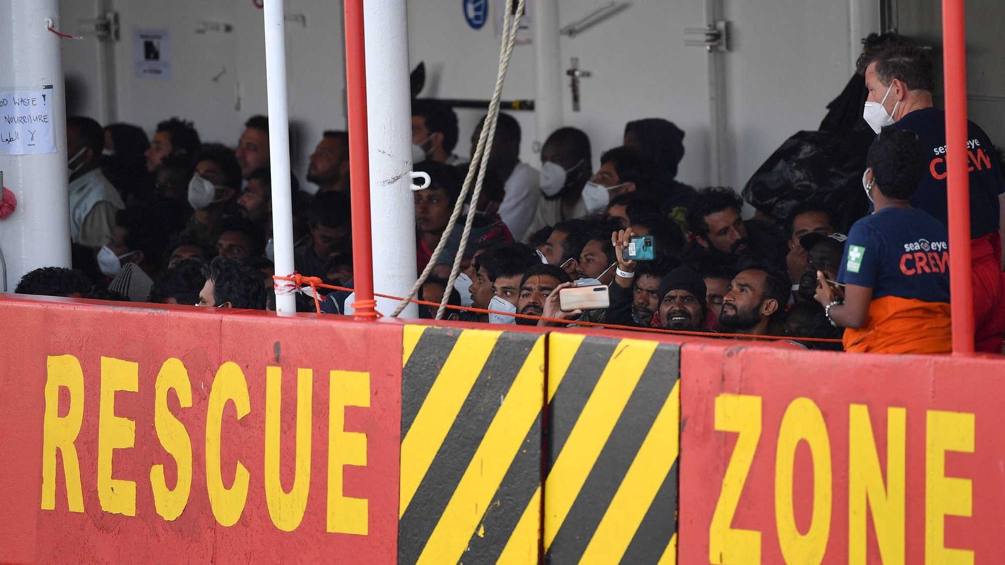 epa10027608 People wait to disembark the Sea Eye 4 rescue ship with 476 migrants on board, as it docks at the port of Messina, Italy, 22 June 2022. Another ship, the Sea Watch 4, carrying over 300 people, was still waiting for permission to dock.  EPA/CARMELO IMBESI