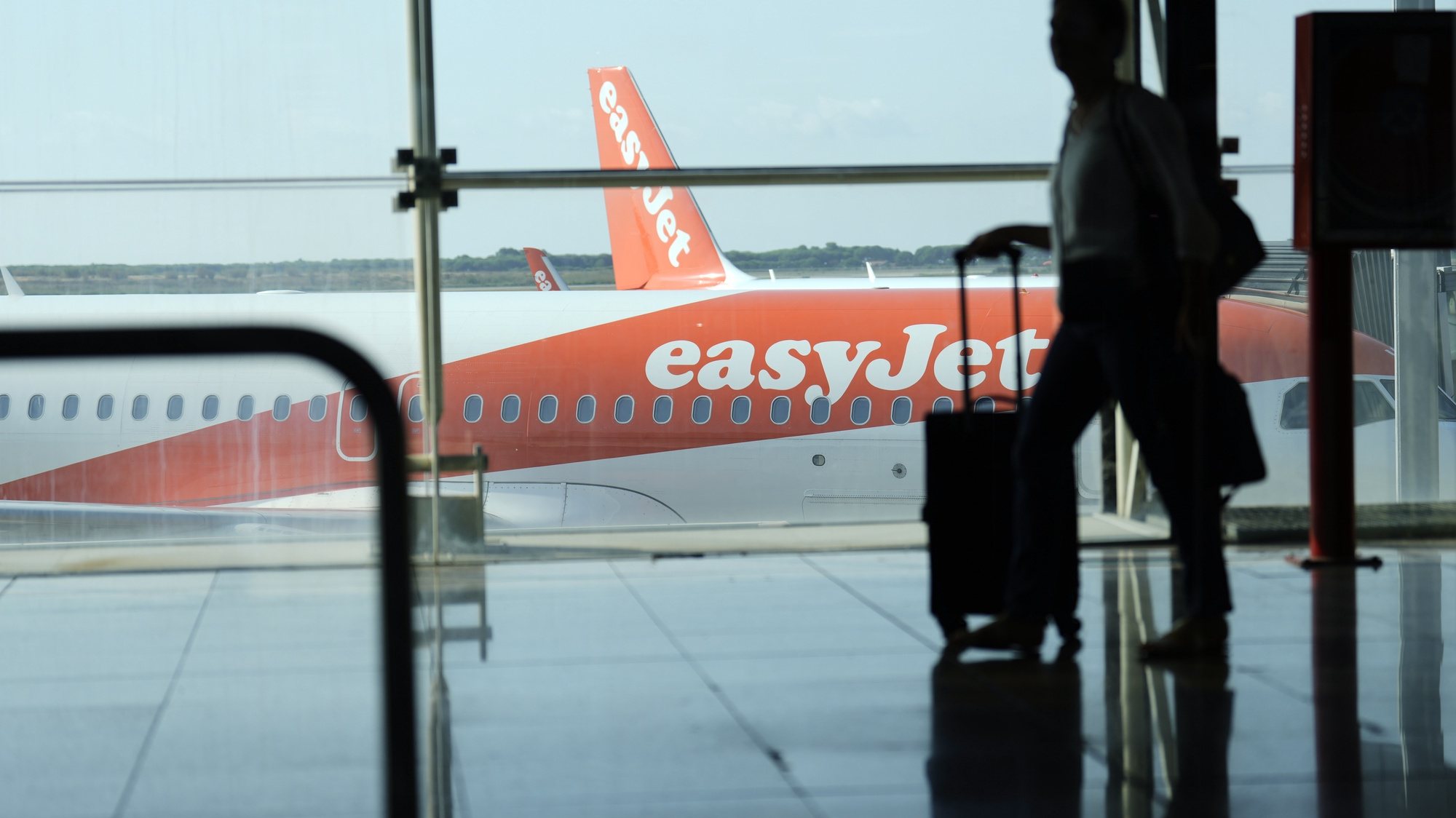 epa10116908 A man walks past an EasyJet plane at El Prat airport, Barcelona, Spain, 12 August 2022. The first day of the EasyJet pilots&#039; strike in August has caused cancellations at El Prat and in Palma de Mallorca Airports.  EPA/ALEJANDRO GARCIA