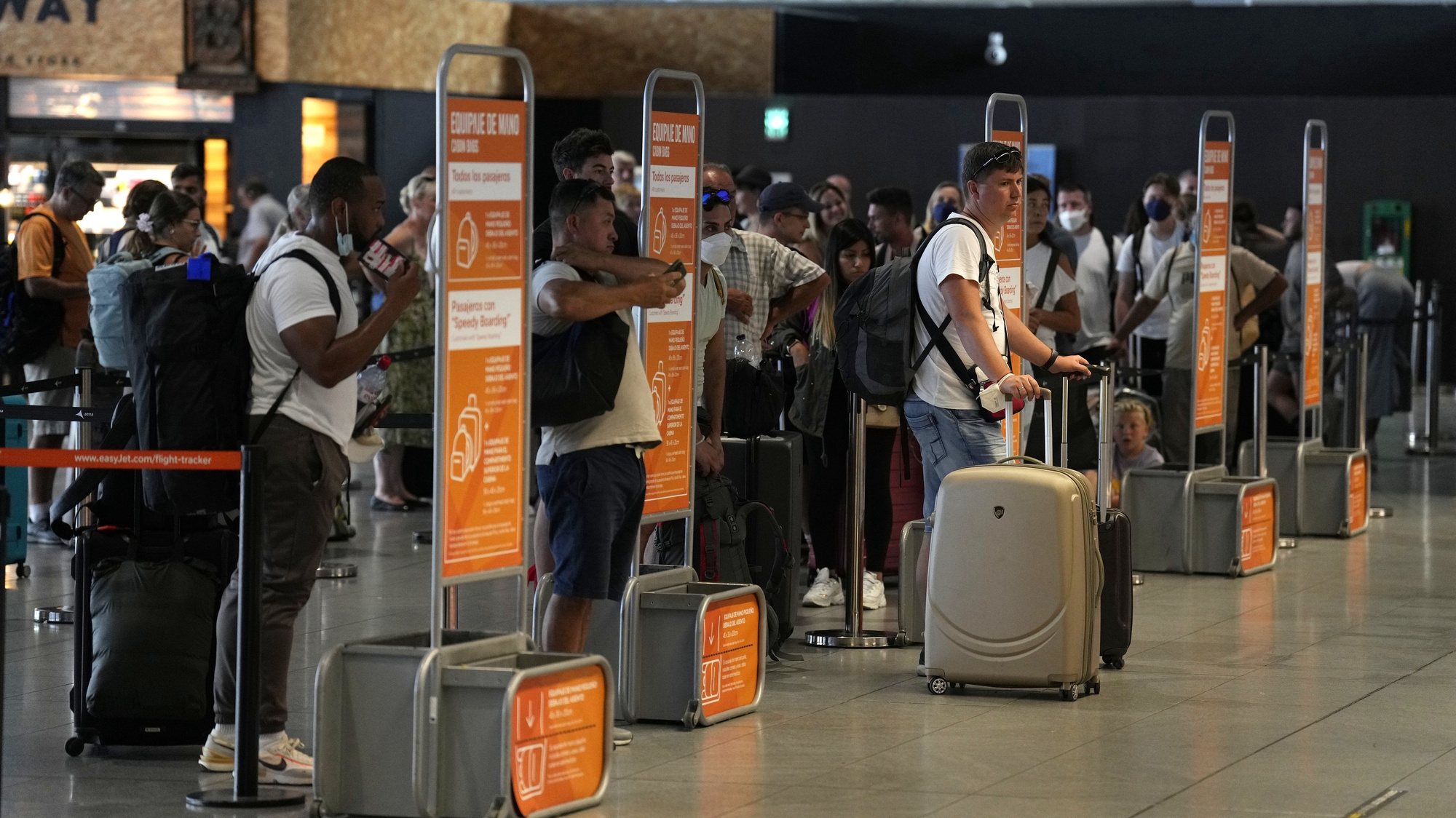 epa10116910 Passengers wait in line at a check-in desk at El Prat Airport in Barcelona, Spain, 12 August 2022. The first day of the EasyJet pilots&#039; strike in August has caused cancellations at El Prat and in Palma de Mallorca Airports.  EPA/ALEJANDRO GARCIA