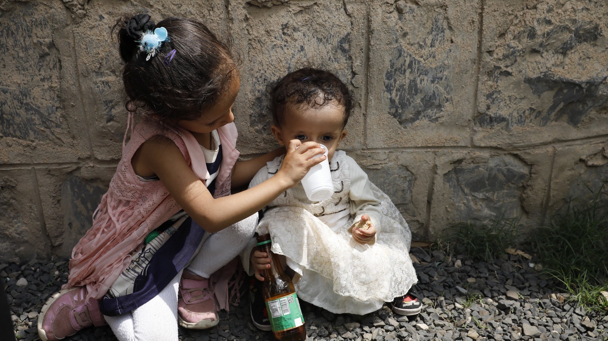 epaselect epa09408553 A Yemeni child (L) helps her malnourished sister to drink water as they wait to get food aid provided by Mona relief agency in Sana&#039;a, Yemen, 10 August 2021. The International Committee of the Red Cross (ICRC) has warned that over 2.2 million children under age five in Yemen are projected to suffer from acute malnutrition in 2021 due to the country’s prolonged conflict which has had a devastating effect on children. Yemen has been mired in war since the Houthis ousted the Saudi-backed government from power in late 2014, exacerbating what the UN calls the world&#039;s worst humanitarian crisis.  EPA/YAHYA ARHAB