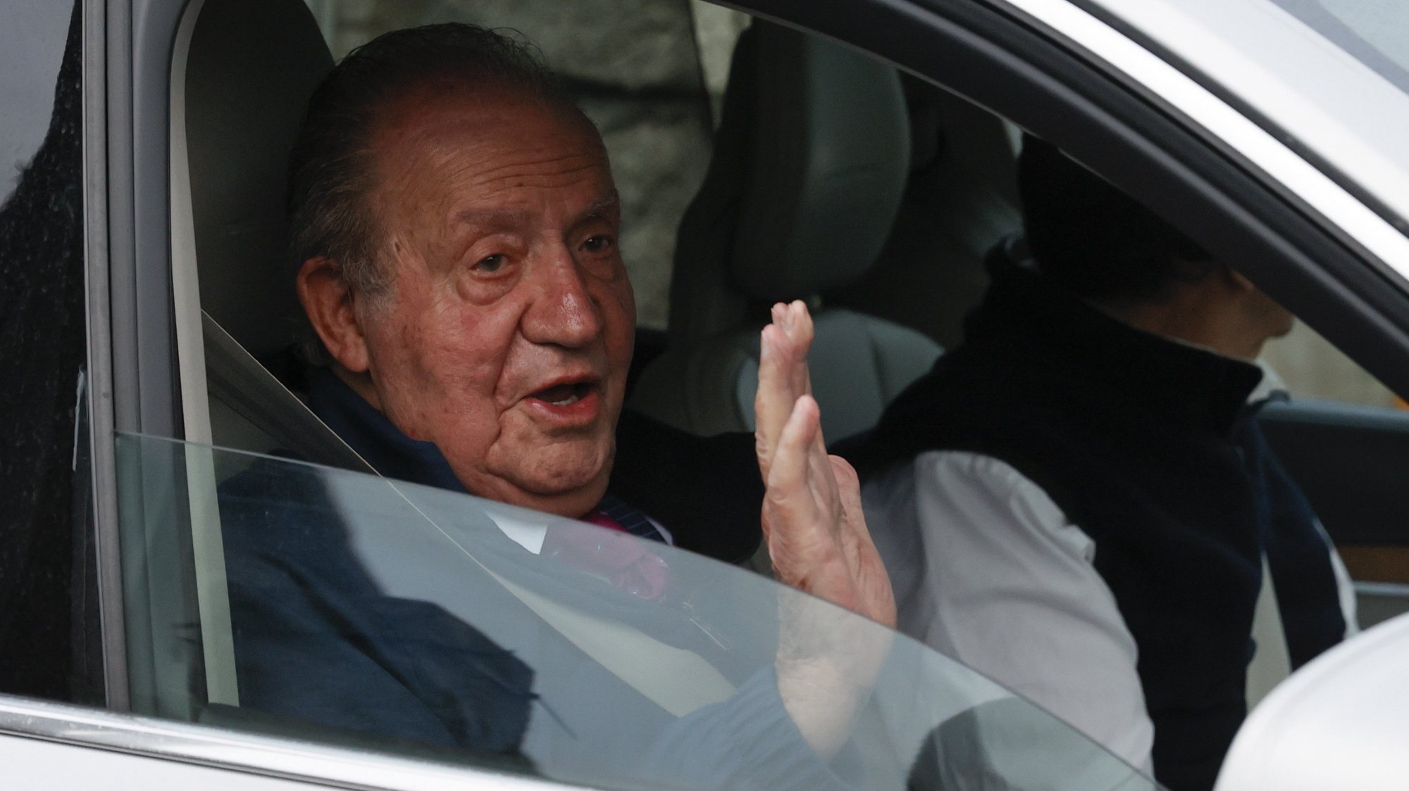 epaselect epa09968162 Spanish Emeritus King Juan Carlos I waves as he leaves the village of Sanxenxo, Galicia, Spain, 23 May 2022, before meeting his son, King Felipe VI of Spain at Zarzuela palace. The former king has returned for the first to Spain after a two-year self-imposed exile in the United Arab Emirates, where he fled in 2020 amid investigations over a corruption scandal.  EPA/LAVANDEIRA JR.