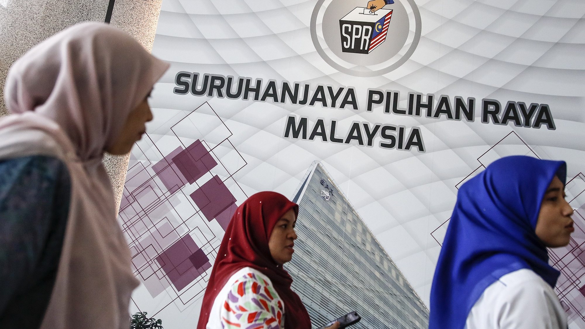 epa10253783 Suruhanjaya Pilihan Raya (SPR) Malaysia (Malaysia Election Commission) officers walk past the commission&#039;s logo prior to a press conference in Putrajaya, Malaysia, 20 October 2022. Malaysians will go to the polls for the 15th general election (GE15) on 19 November with nominations on 05 November 2022.  EPA/FAZRY ISMAIL