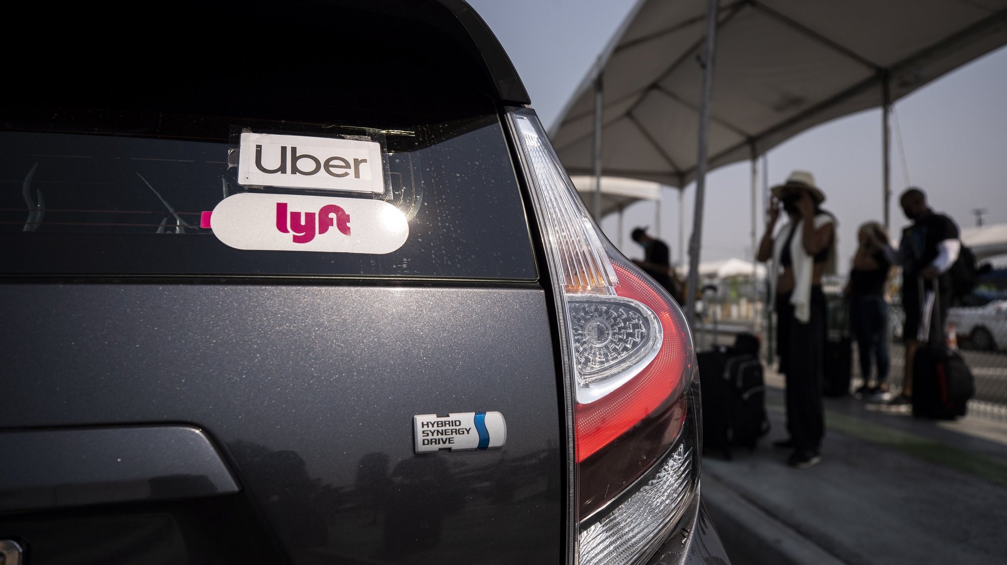 epa08615328 The Uber and Lyft stickers are displayed on a car at LAX Rideshare Lot 1 as Mobile Workers Alliance organizes a rally close by as part of a statewide day of action to demand that both ride-hailing companies follow California law and grant drivers basic employee rights and to denounce the corporations efforts to avoid their responsibilities to workers, in Los Angeles, California, USA, 20 August 2020. Lyft and Uber threatened this morning to shut down their operation in California tonight at 11.59pm, but an emergency stay granted by a state appeal court allowed Uber and Lyft to continue operating without reclassifying their drivers.  EPA/ETIENNE LAURENT
