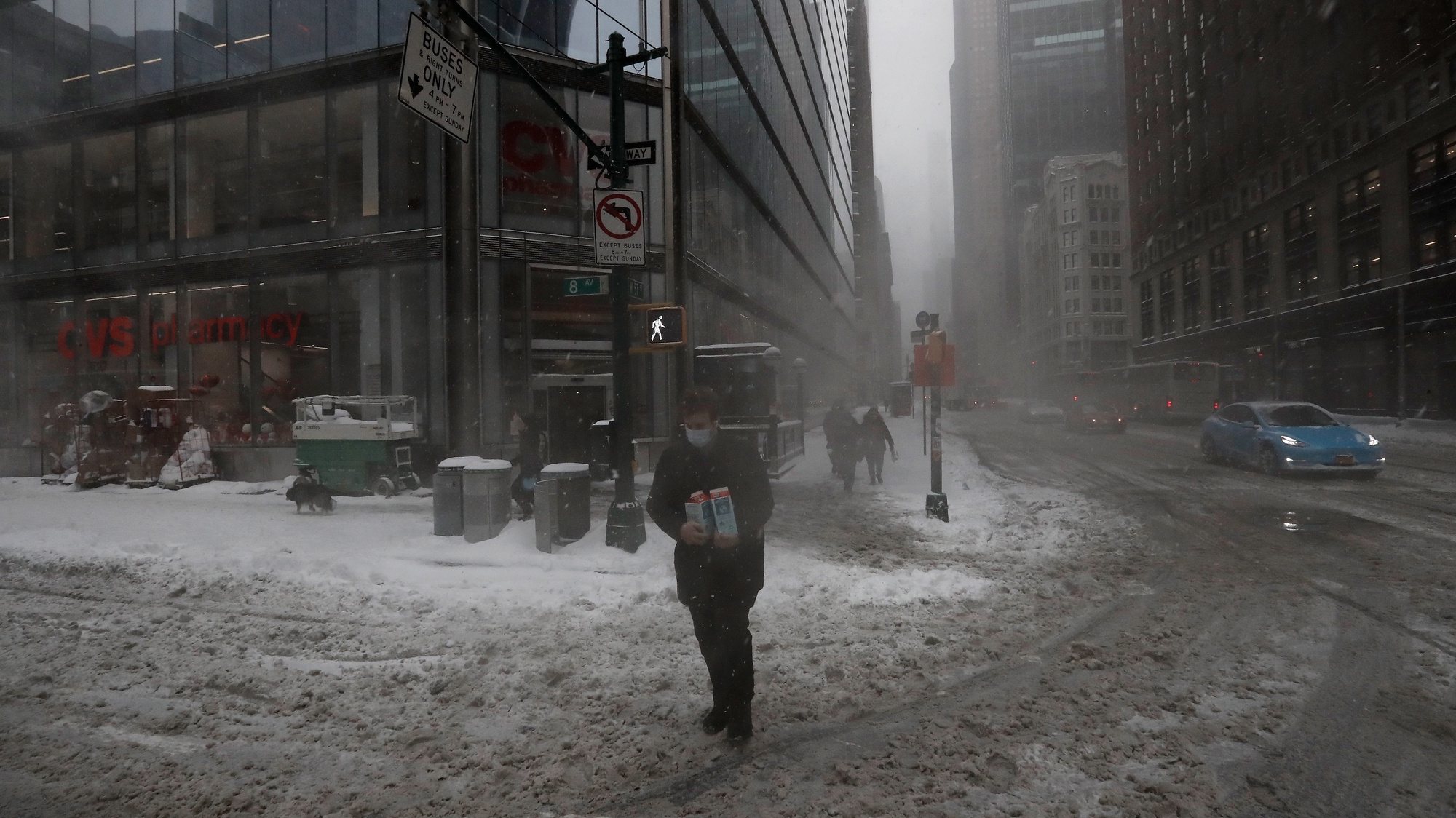 epa09717090 A man carries containers of milk across Eighth Avenue in New York, New York, USA, 29 January 2022. The large storm is hitting a substantial portion of the East Coast of the United States, disrupting travel and some areas are forecast to receive up to 2 feet (61 centimeters) of snow.  EPA/Peter Foley