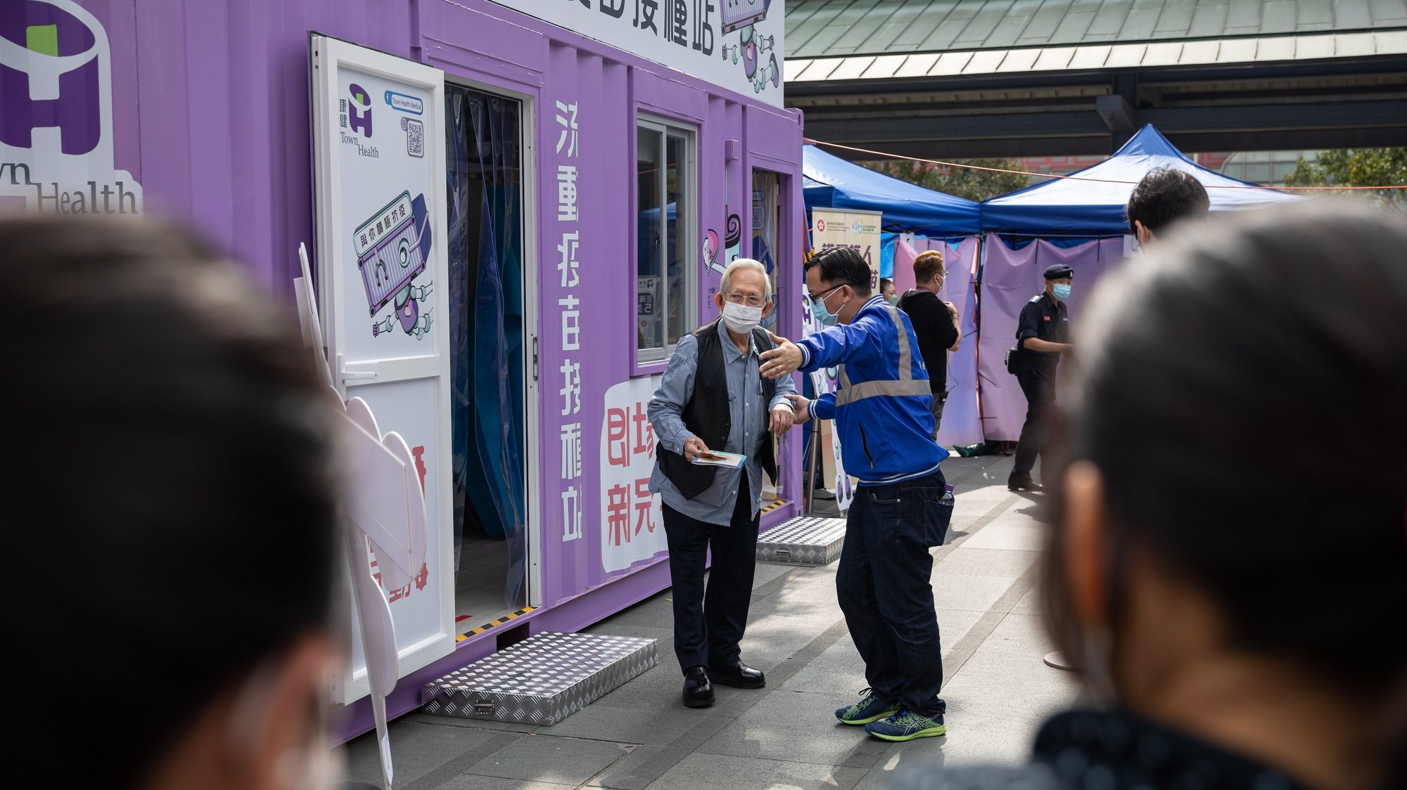 epa09671253 A man is directed to a rest area after receiving a BioNTech COVID-19 vaccine in a Mobile Vaccination Station in Hong Kong, China, 07 January 2022. The COVID-19 Mobile Vaccination Station facilitates the vaccination of elderly persons and also offers walk-in services.  EPA/JEROME FAVRE