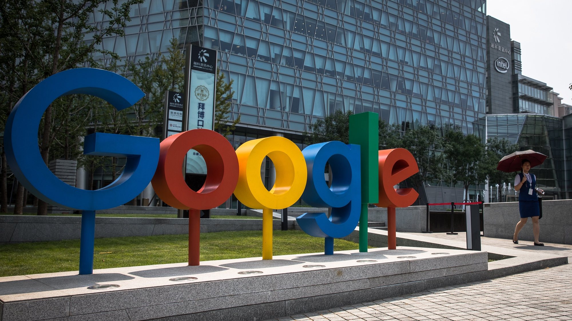 epa08873749 (FILE)  A Chinese woman walks next to a &#039;Google&#039; brand name and logo, near the Google office in Beijing, China, 03 August 2018 (reissued 10 December 2020). According to media reports on 10 December 2020, French data privacy regulator CNIL will impose over 100 million euros fines on US companies Google and Amazon for breaching EU privacy data rules. According to media reports, Google will have to pay 100 million euros and Amazon 35 million euros fines.  EPA/ROMAN PILIPEY *** Local Caption *** 55208312