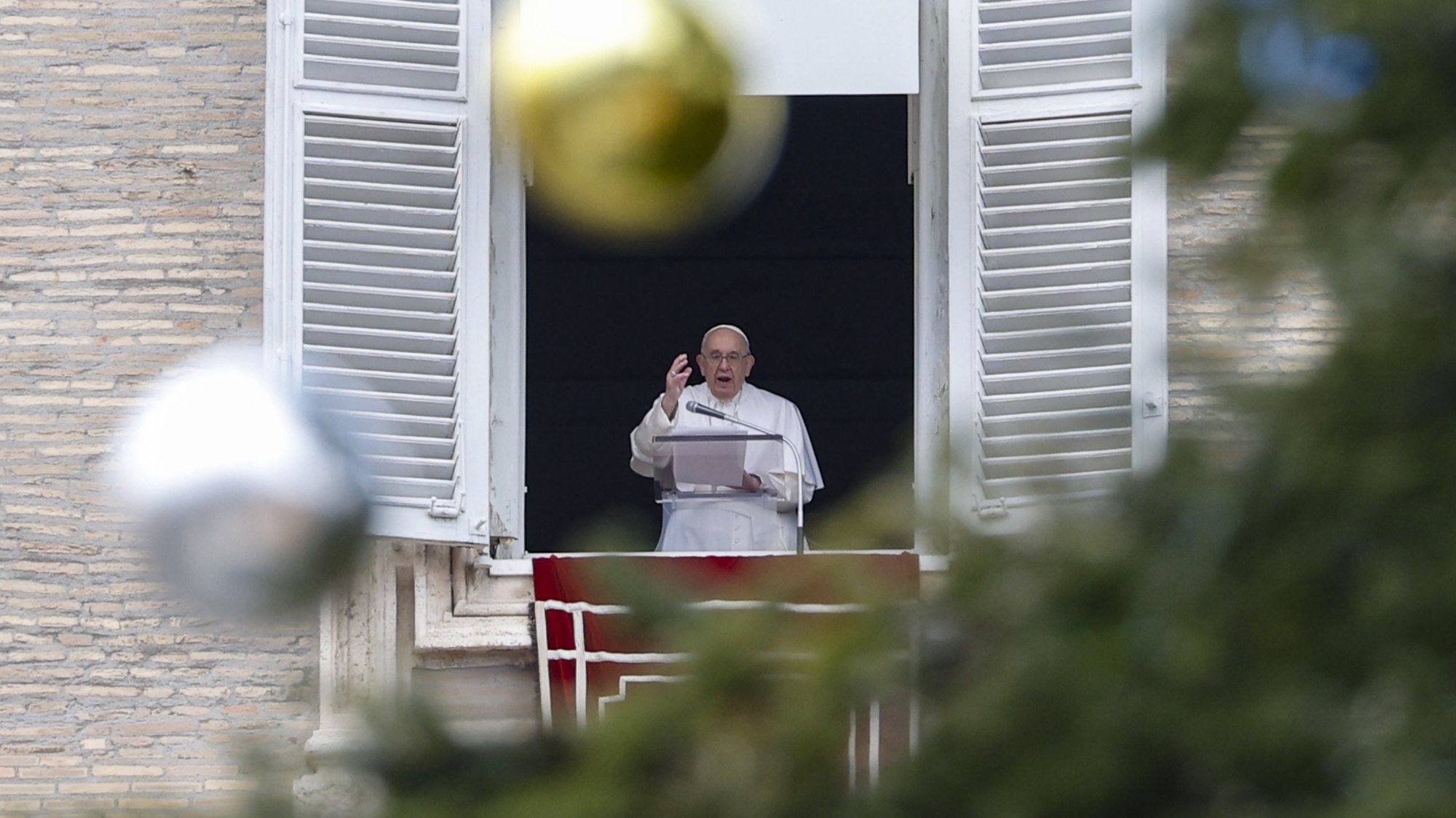 epa10347681 Pope Francis, framed by the branches and decorations of a Christmas tree, leads his Sunday Angelus prayer from the window of his office overlooking Saint Peter&#039;s Square, in Vatican City, 04 December 2022.  EPA/FABIO FRUSTACI ITALY OUT