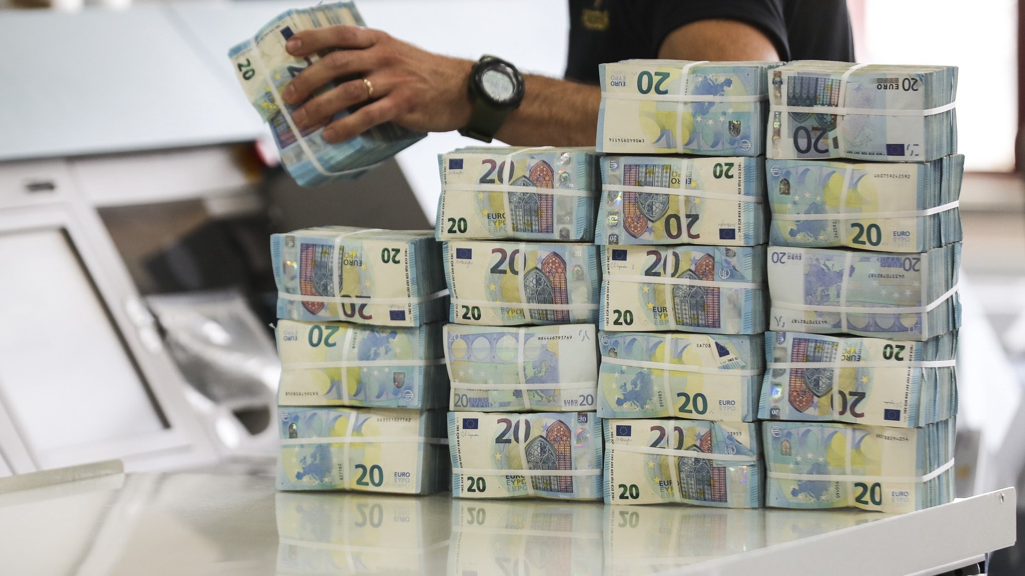 Um funcionário manuseia pacotes de notas de 20 Euros no complexo do Banco de Portugal, durante a iniciativa que marca o encerramento das comemorações dos 20 anos do Euro, no Carregado, 17 de maio de 2022. MIGUEL A. LOPES/LUSA