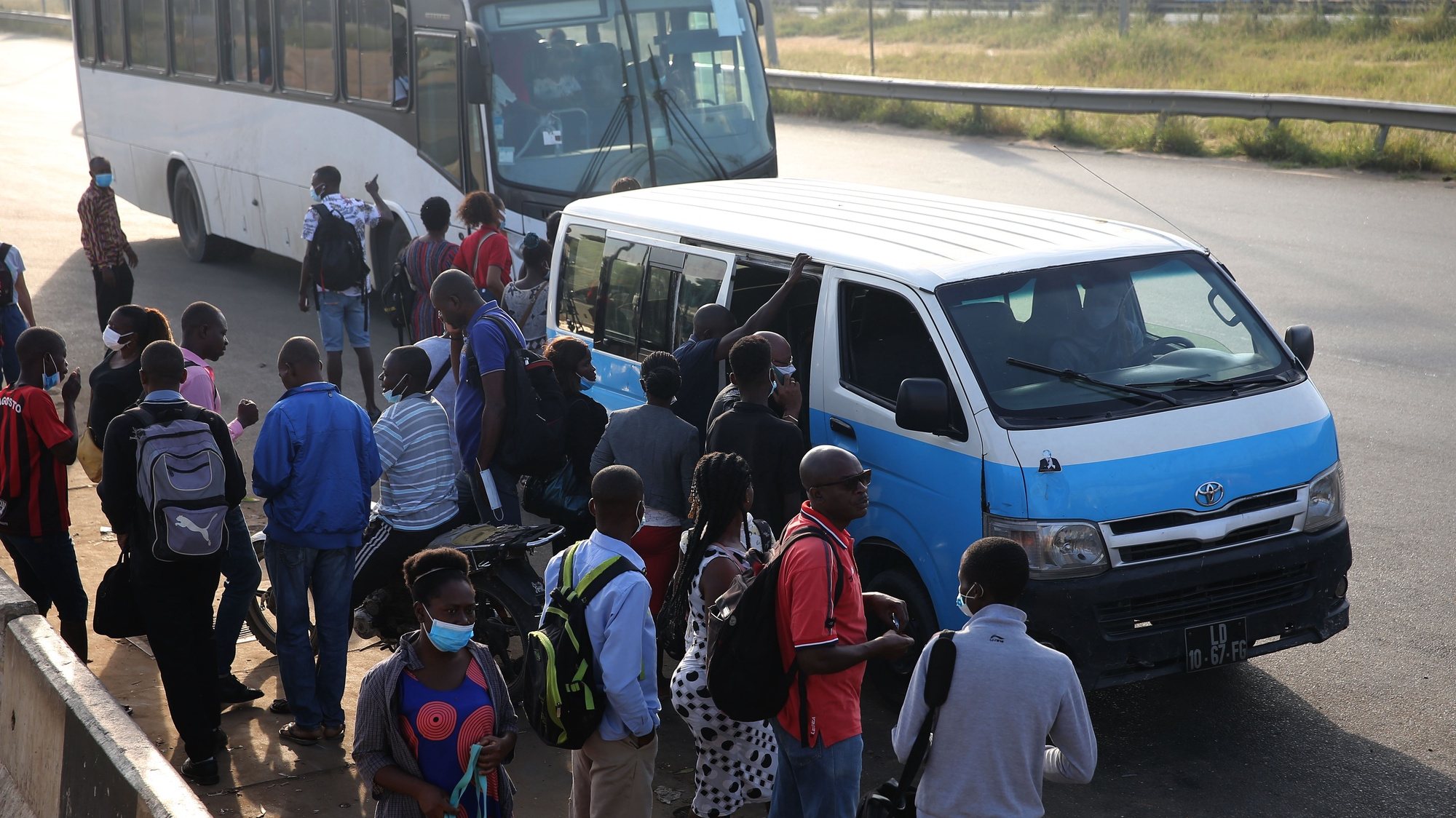 Passageiros entram e saem de um táxi “azuis e brancos” em Luanda, Angola, 21 de janeiro de 2022. Cada “táxi” ou “quadradinho”, normalmente uma pequena carrinha que leva até 15 passageiros, dá emprego a, pelo menos, um motorista, um cobrador e um lotador, nome dado aos jovens que, nas paragens, angariam os clientes e ajudam a “lotar” a viatura. (ACOMPANHA TEXTO DA LUSA DE 22 DE JANEIRO DE 2022). AMPE ROGÉRIO/LUSA