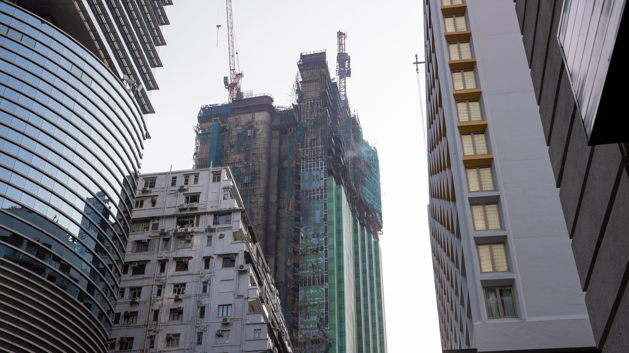 epa10499726 Smoke rises out of a building under-construction hit by fire in Tsim Sea Tsui district, Hong Kong, China, 03 March 2023. Two people were taken to hospital after a blaze broke out in the skyscraper in one of the city&#039;s major shopping districts  EPA/JEROME FAVRE