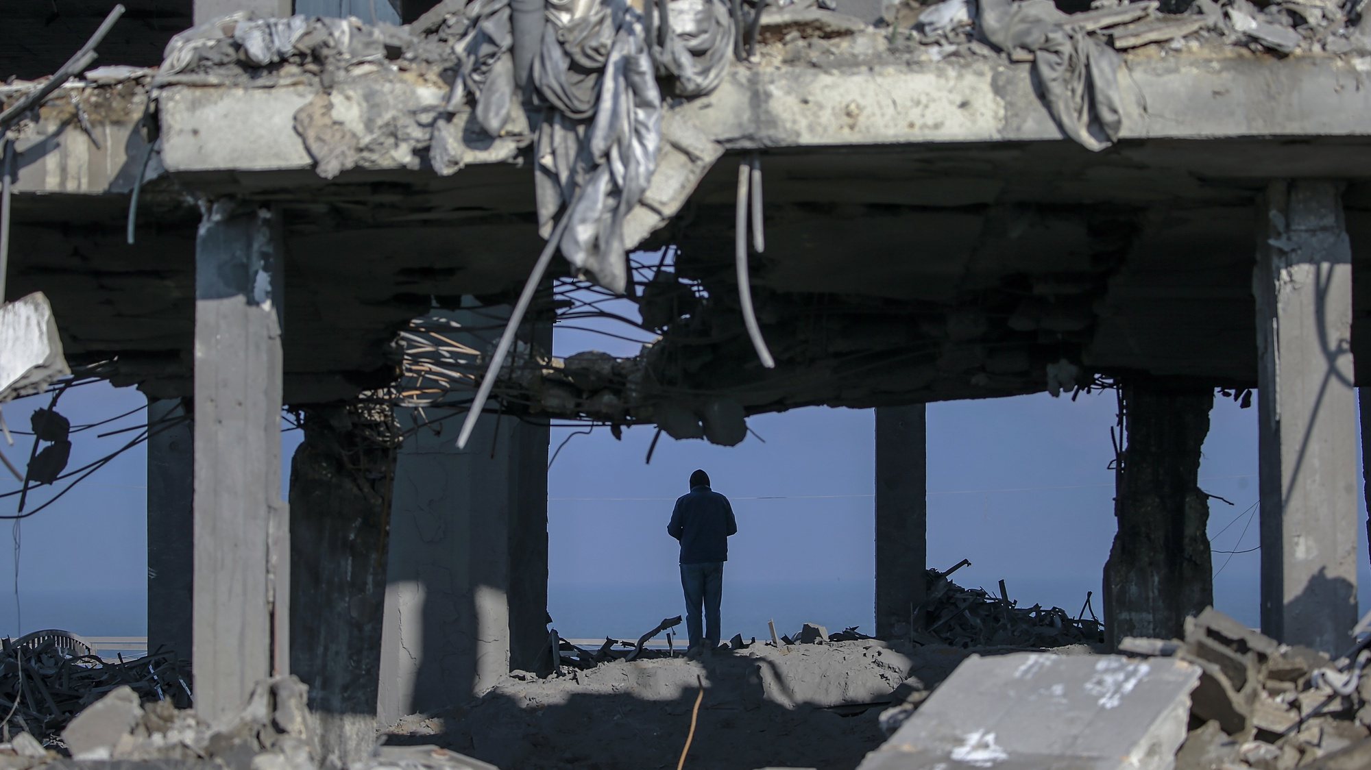 epa10464557 A Palestinian inspects the rubble of a destroyed building after an Israeli air strike in central Gaza Strip, 13 February 2023. Israel launched air strikes in the Gaza Strip early 13 February, hours after the Israeli forces said they intercepted a rocket fired from the area.  EPA/MOHAMMED SABER