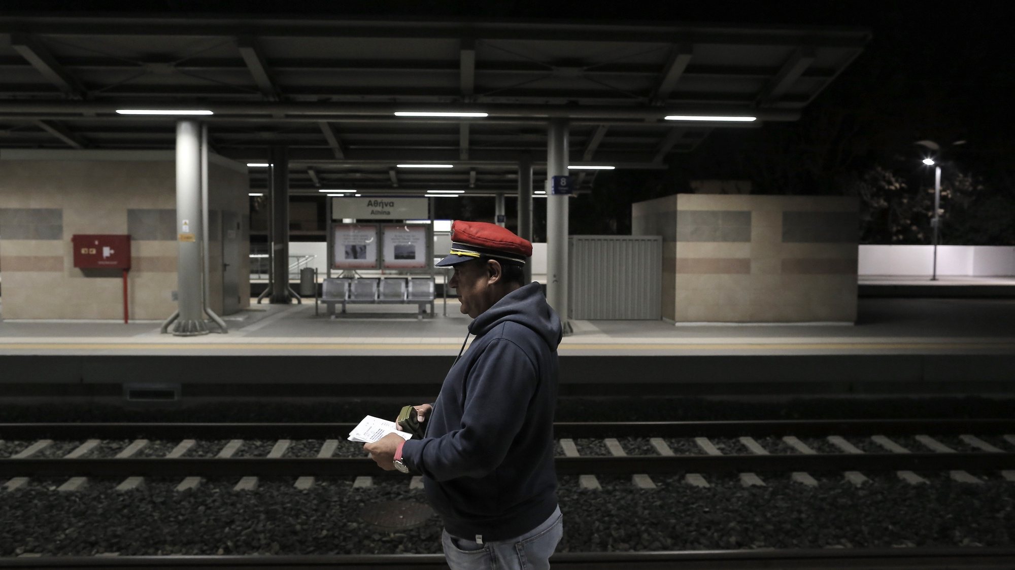 epa10536154 A station master walks along a platform of a train station in Athens, Greece, 22 March 2023. Greek trains and the suburban railways gradually resumed operation early 22 March after services throughout Greece were suspended following a deadly head-on crash between two trains along the Athens-Thessaloniki line on the night of 28 February which claimed the lives of 57 people.  EPA/KOSTAS TSIRONIS