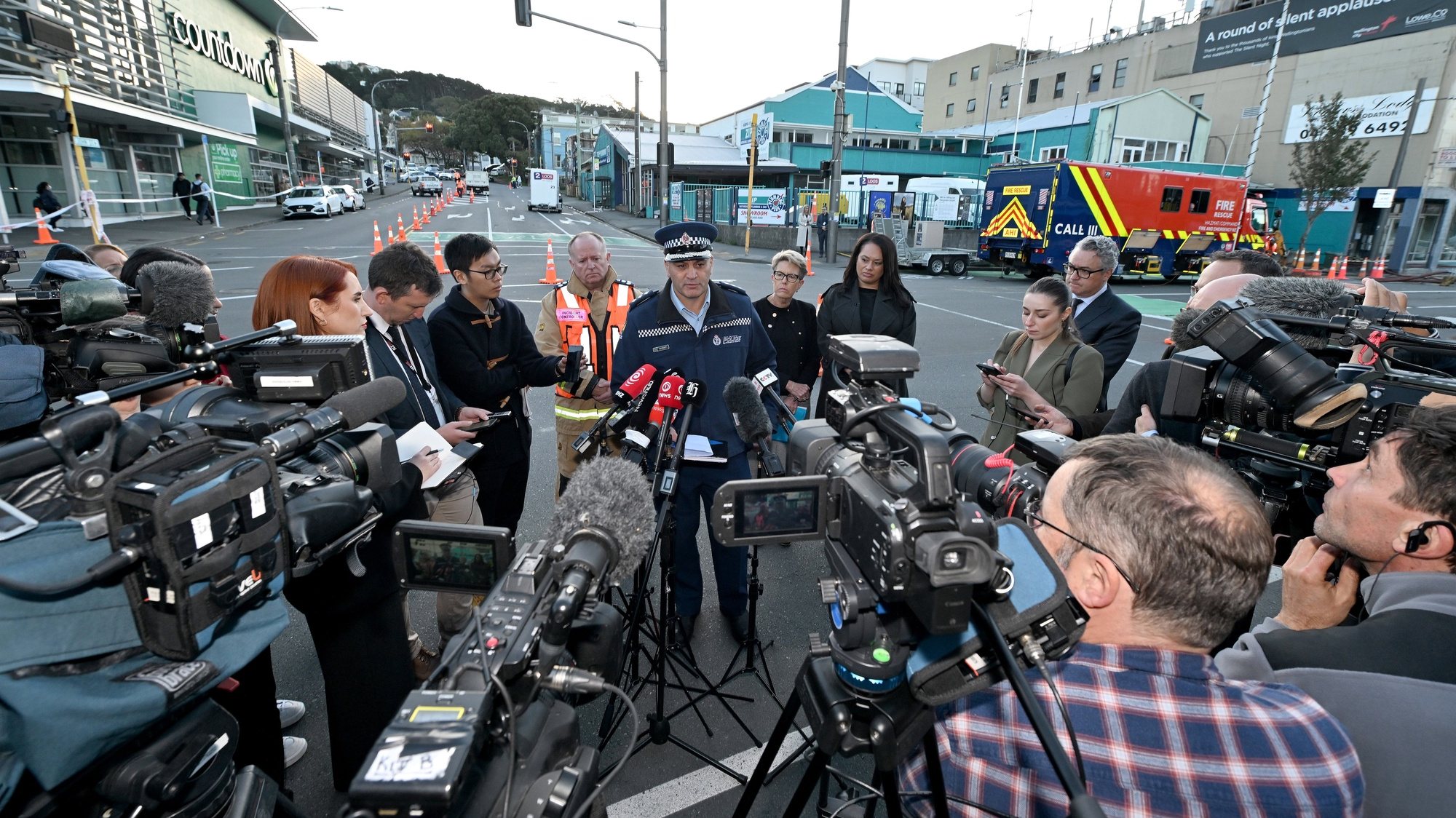 epa10630621 Acting district commander for Wellington Police Inspector Dion Bennett (C) speaks to the media at the scene of a fatal hostel fire in Wellington, New Zealand, 16 May 2023. Multiple people are believed to be dead after a fire ripped through the 92-room hostel.  EPA/MASANORI UDAGAWA  AUSTRALIA AND NEW ZEALAND OUT
