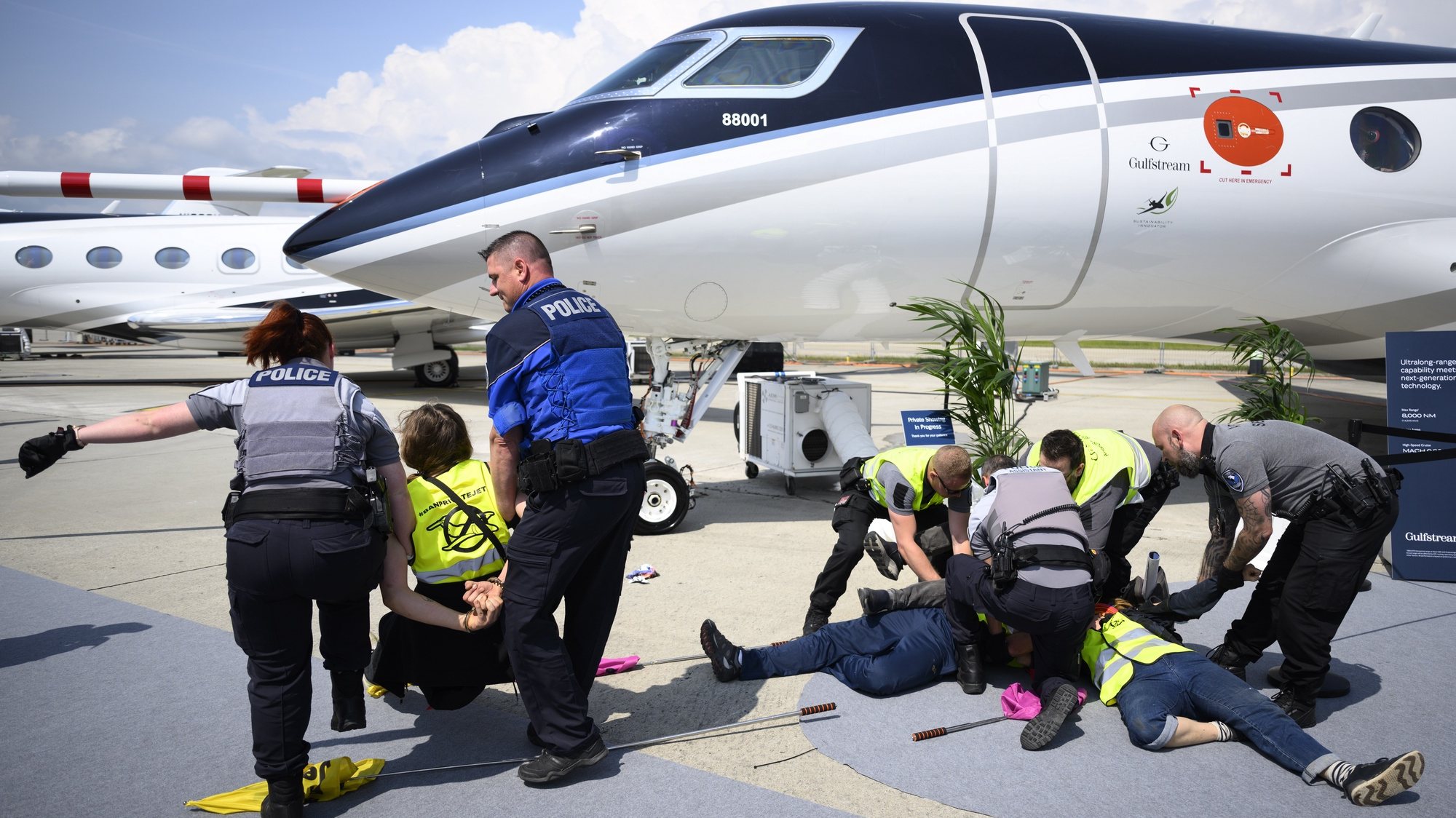 epa10647637 Police officers arrest environmental activists of Stay Grounded, Greenpeace, Extinction Rebellion and Scientist Rebeillion as they protest by being handcuffed to an aircraft during the European Business Aviation Convention and Exhibition (EBACE), at the Geneva Airport in Geneva, Switzerland, 23 May 2023. Europe&#039;s premier on-demand aircraft and advanced air mobility event is taking place in Geneva from 23 to 25 May.  EPA/LAURENT GILLIERON