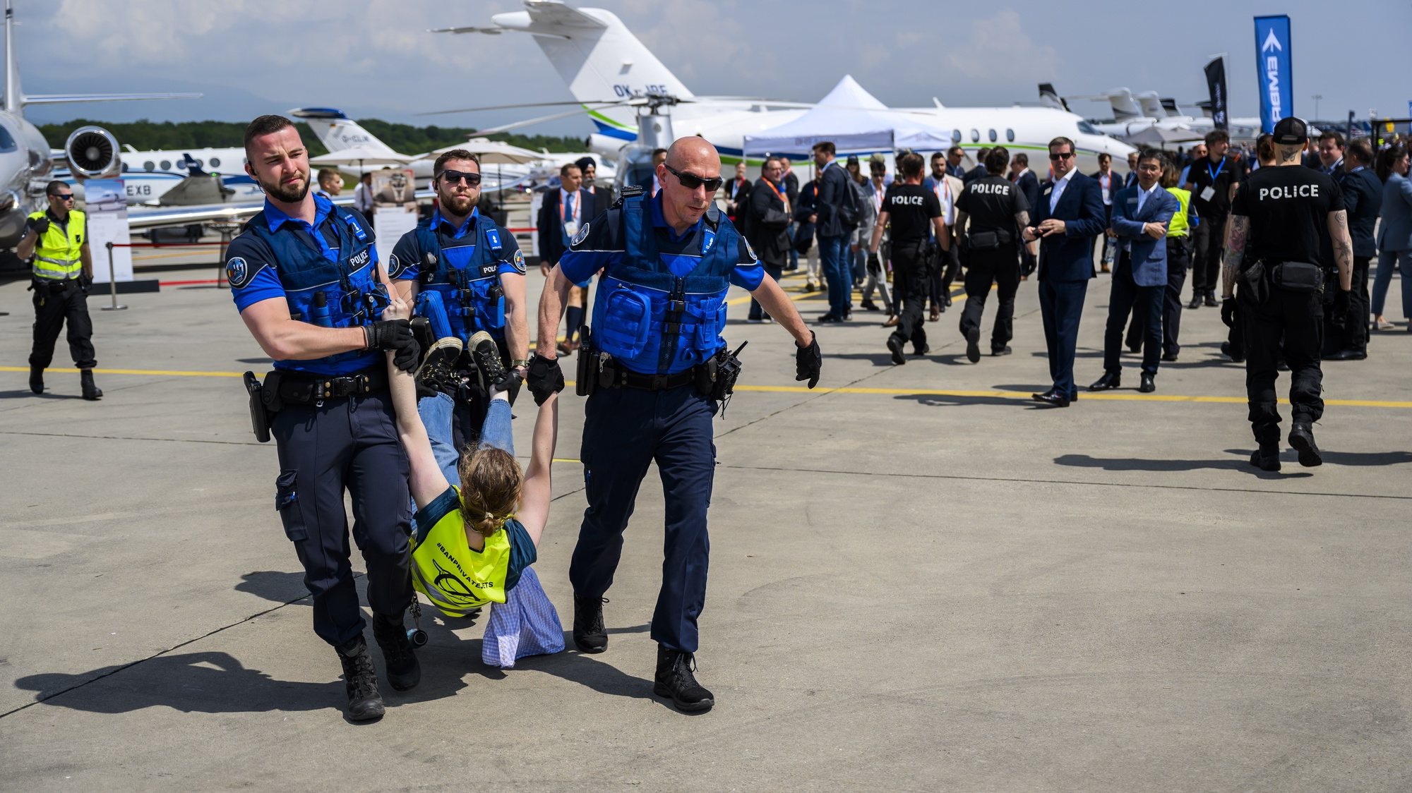 epa10647424 Police officers carry out an environmental activist of Stay Grounded and Greenpeace as they protest around an aircraft during the European Business Aviation Convention and Exhibition (EBACE), at the Geneva Airport in Geneva, Switzerland, 23 May 2023. Europe&#039;s premier on-demand aircraft and advanced air mobility event is taking place in Geneva from 23 to 25 May.  EPA/LAURENT GILLIERON