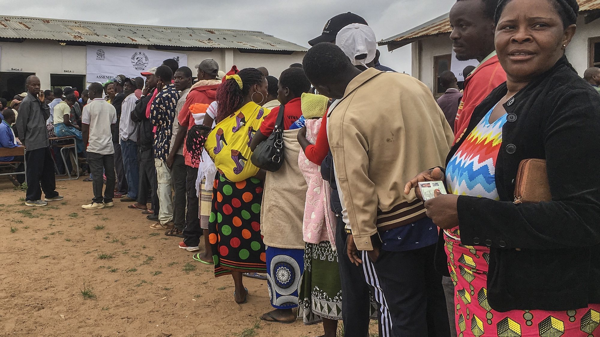 epa07921897 People queue in line as they wait to vote outside a polling station in Chimoio, Manica Province, Mozambique, 15 October 2019. Some 12.9 million Mozambican voters will choose the President of the Republic, ten provincial assemblies and their governors, as well as 250 members of the Assembly of the Republic.  EPA/ANDRE CATUEIRA