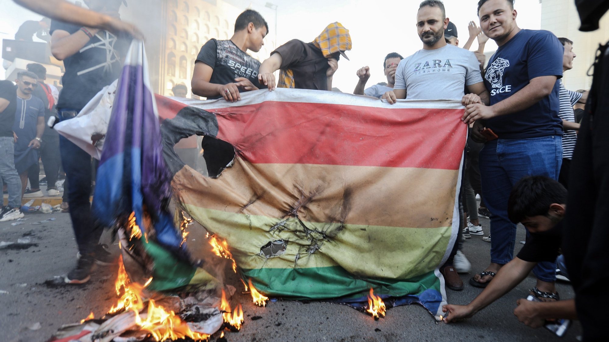 epa10719869 Iraqi demonstrators burn a rainbow flag, symbol of the international LGBT community, during a protest near the Swedish embassy in Baghdad, Iraq, 30 June 2023. Hundreds of protesters gathered near the Swedish embassy building in Baghdad following a call for an &#039;angry&#039; demonstration by Iraqi Shiite cleric Muqtada al-Sadr over the burning of a copy of the Koran in Stockholm.  EPA/AHMED JALIL