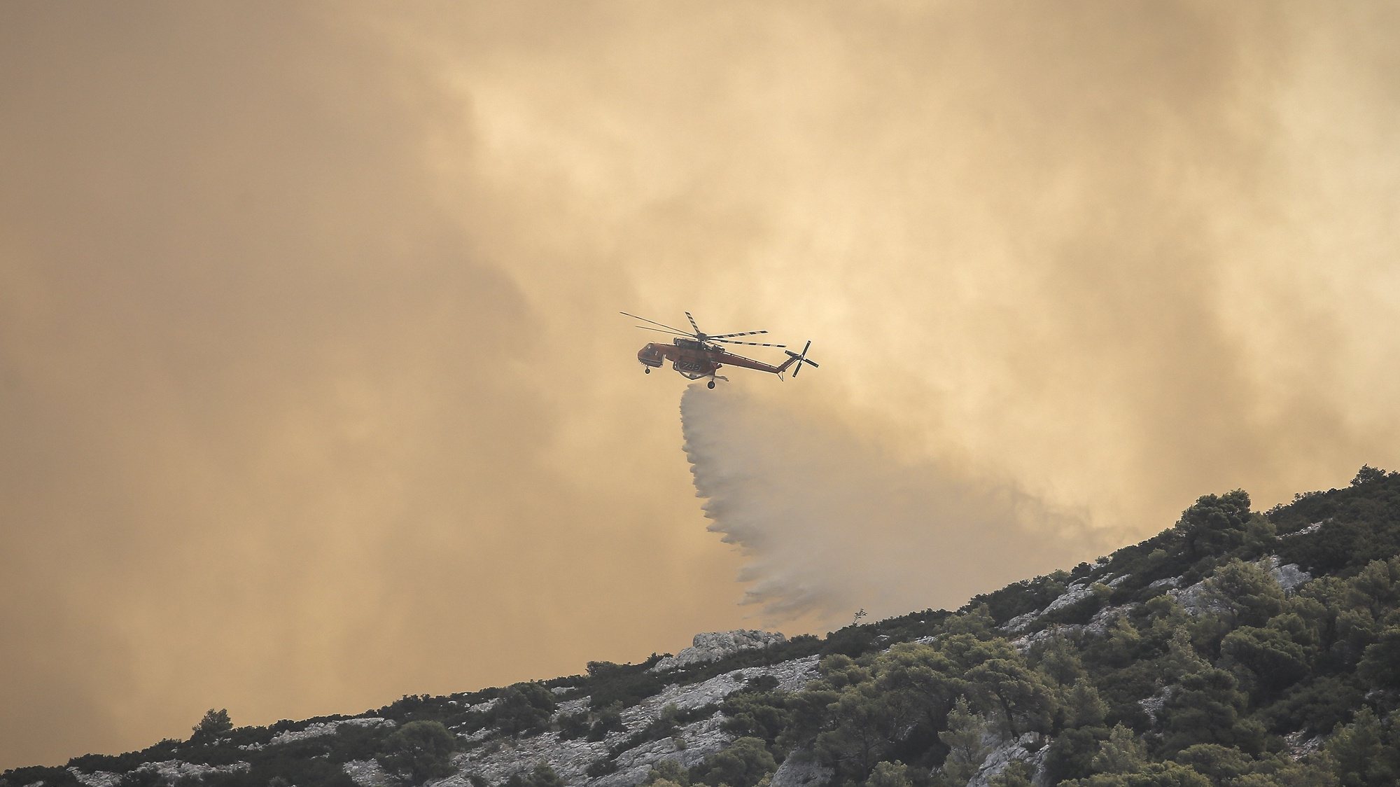 epa10813348 A firefighting plane operates above a wildfire in the area of Fyli near Athens, Greece, 22 August 2023. A wildfire is in progress in Fyli, west Attica region. So far, 26 firefighters with 13 vehicles are operating, while air forces have also been mobilized.  EPA/KOSTAS TSIRONIS