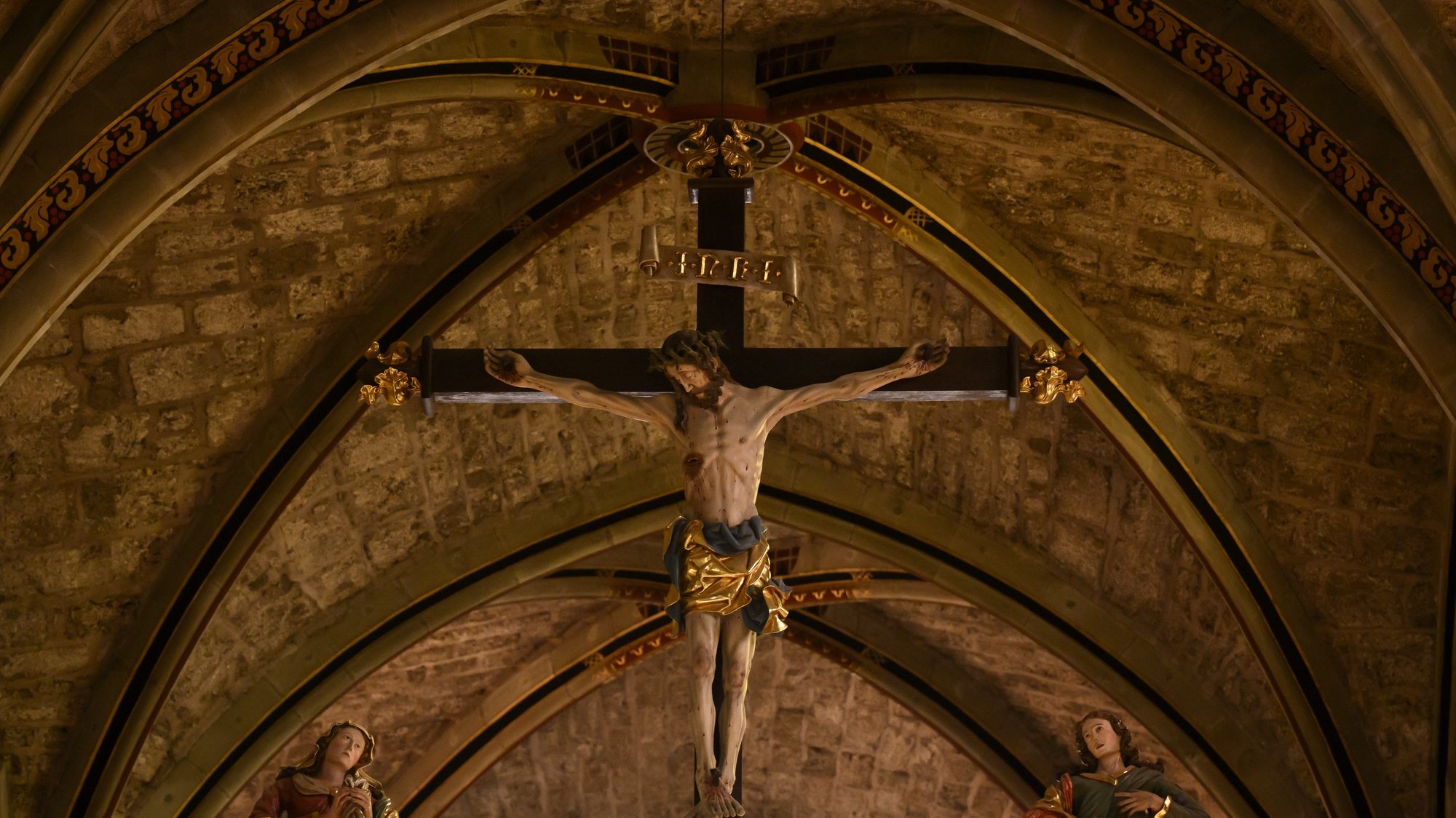 epa09891645 A statue representing the crucified Christ during the Good Friday mass at the Collegiale de Notre-Dame de l&#039;Assomption church in Romont, Fribourg, Switzerland, 15 April 2022. Following the Good Friday mass in a ceremony to commemorate the suffering and death of Jesus, veiled women known as &#039;Les Pleureuses&#039; (The Mourning Women) carry the symbols of the Passion: a crown of thorns, a whip, a hammer, tongs, and St. Veronica&#039;s shroud, preceded by a penitent, wearing a black hood and carrying a large cross.  EPA/ANTHONY ANEX