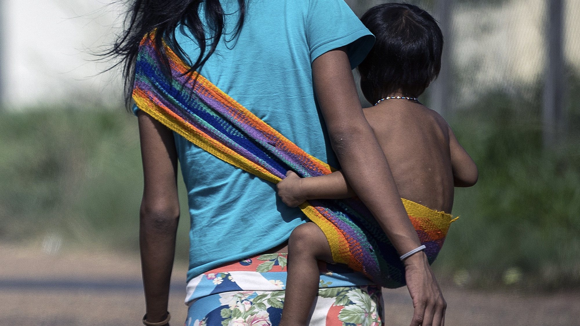 epa10443384 An indigenous Yanomami woman and a baby in a rural area near the Casa de Saude Indigena (CASAI), in Boa Vista, in the Amazonian state of Roraima, Brazil, 01 February 2023. Hundreds of Yanomami are in the capital of the state of Roraima due to the health crisis that thrives on their lands due to the presence of illegal mining. The Brazilian government decreed a state of health emergency on Yanomami land ten days ago, when President Lula visited the area to verify the situation of abandonment in which the indigenous people of that region live. About 21,000 Yanomami, out of a population of 27,000, have been infected with malaria, many suffer from heavy metal poisoning used by illegal miners, and a large number suffer from malnutrition.  EPA/Raphael Alves