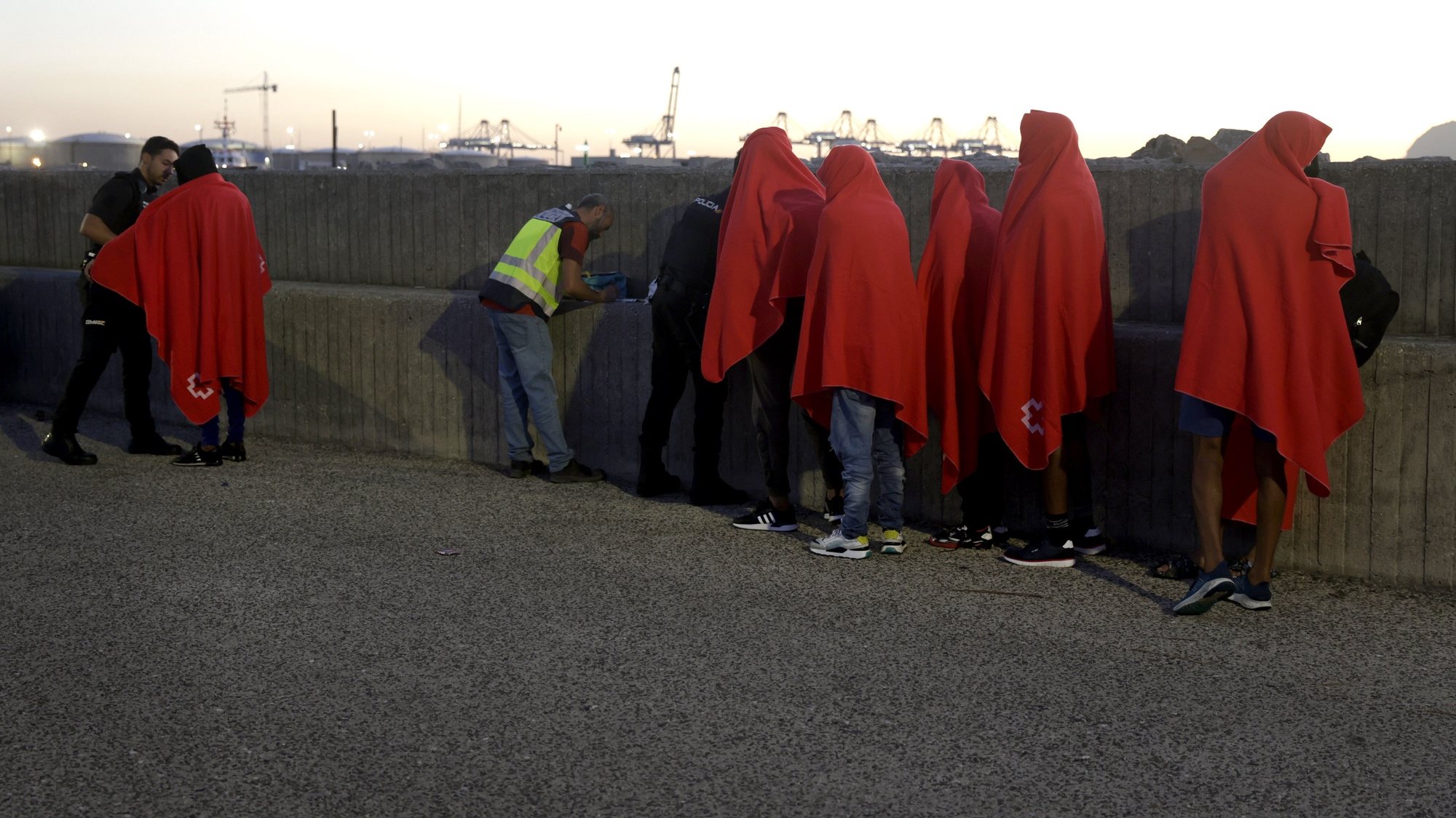 epa10871202 Moroccan migrants wait to be identified by the National Police after being rescued by Spanish Maritime Rescue Forces in the Strait of Gibraltar waters in Cadiz, Spain, 20 September 2023. A total of nine migrants, one of them a minor, were rescued and and taken to the Port of Algeciras in Cadiz.  EPA/A. CARRASCO RAGEL