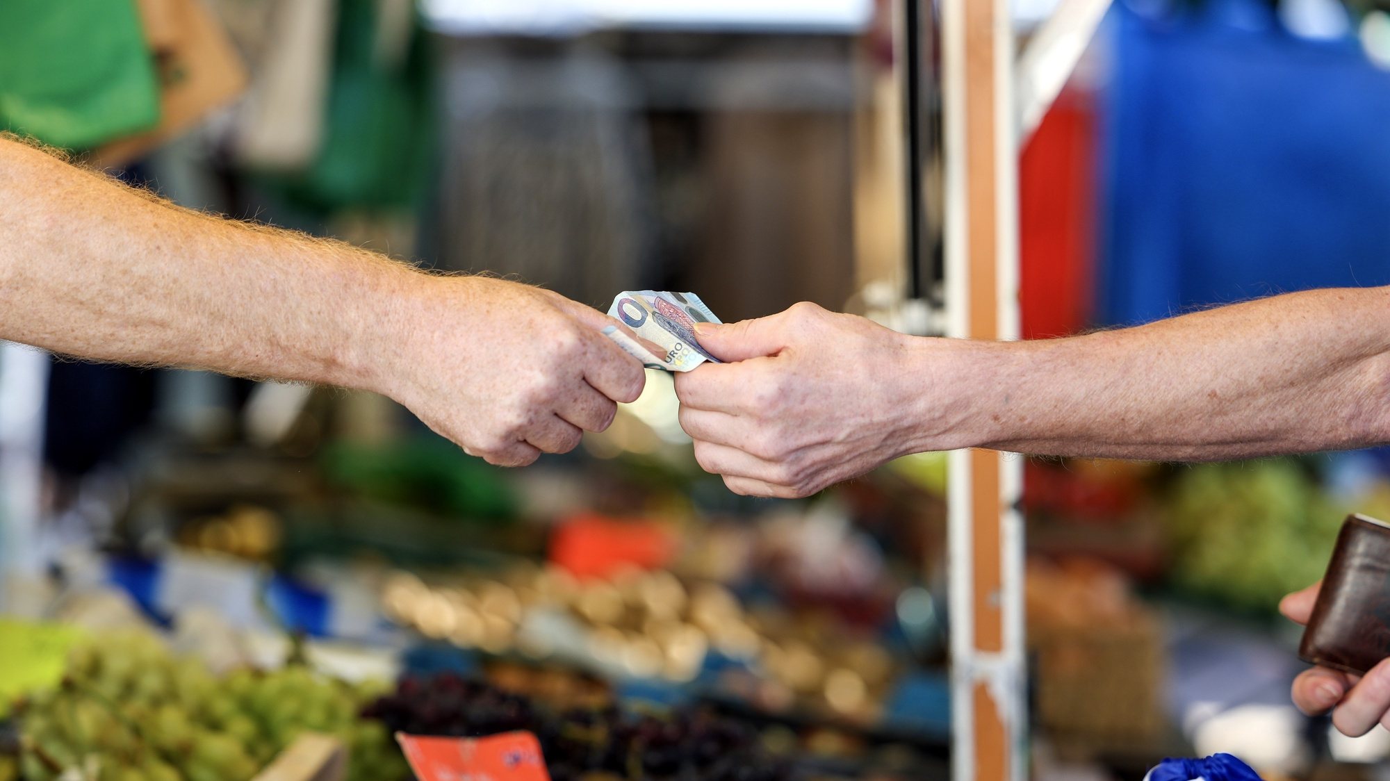 epa10843379 A customer pays for their purchase at a weekly market, in Essen, Germany, 06 September 2023. According to German government&#039;s statistics, food prices in July 2023 were on average 11 percent higher compared to the same period in 2022. German welfare organizations reported in 2022 that 13.8 million people in Germany lived in poverty or were at risk of being below the poverty line.  EPA/CHRISTOPHER NEUNDORF