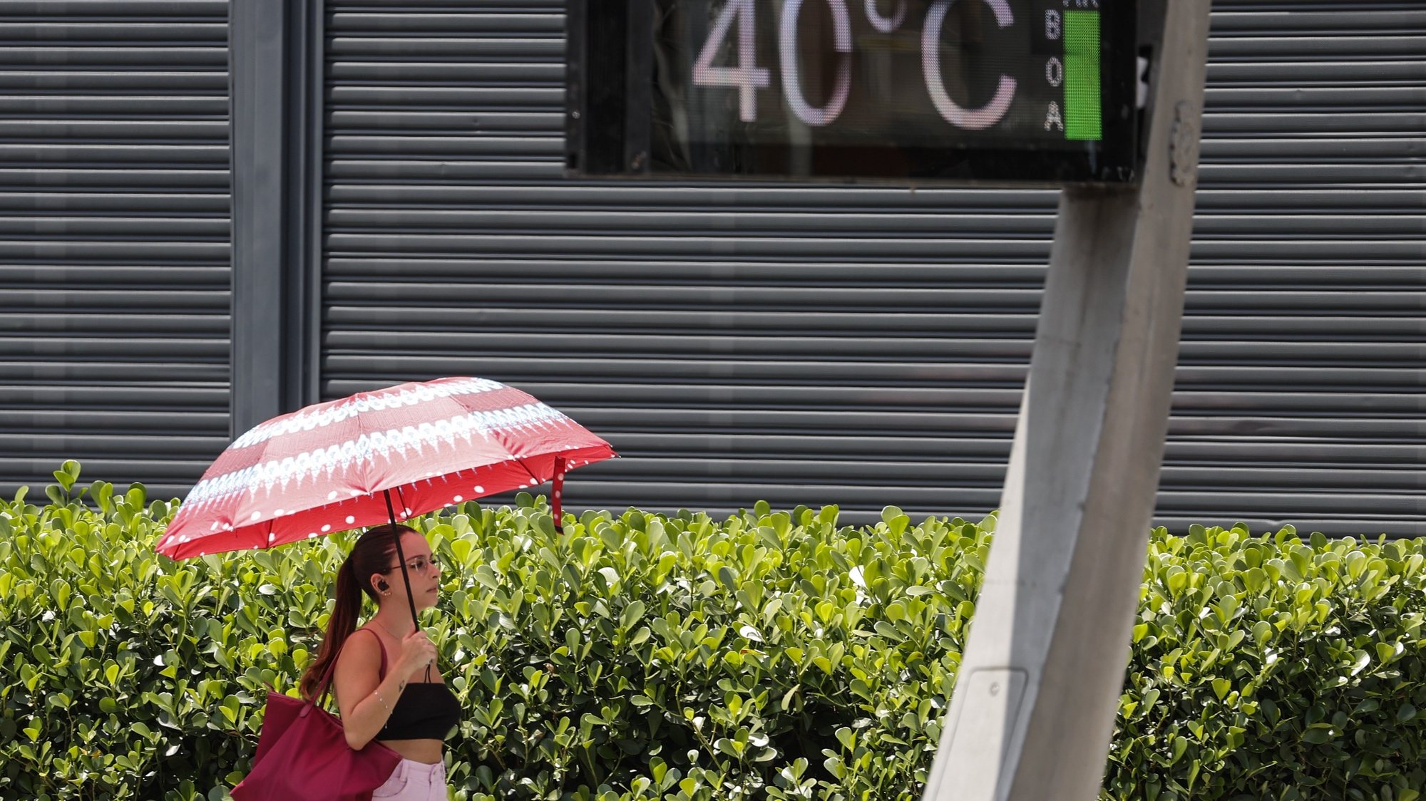 epa10975080 A young woman protects herself from the sun with an umbrella on Paulista Avenue, where urban thermometers register a temperature of 40.0 degrees Celsius in the city of Sao Paulo, Brazil, 14 November 2023. Eight heat waves have been recorded in Brazil so far this year, something that meteorologists attribute to the climate crisis and the El Nino phenomenon.  EPA/Sebastiao Moreira