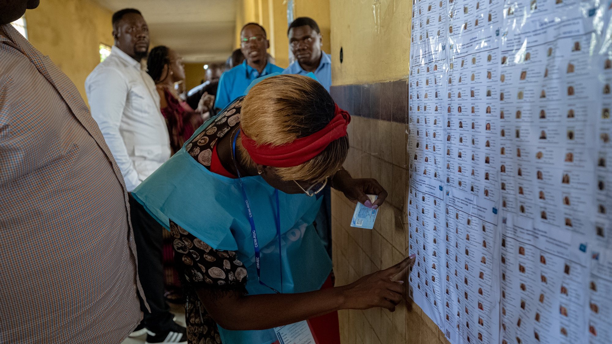 epa11038321 A woman looks at candidates list at a polling station in Kinshasa, Democratic Republic of Congo, 20 December 2023. Almost 44 millions voters, out of a population of over 95 millions, are registered to cast their votes in the legislative and presidential elections. Incumbent President Tshisekedi is running for a second term against 18 other candidates vying for the post.  EPA/CHRIS MILOSI