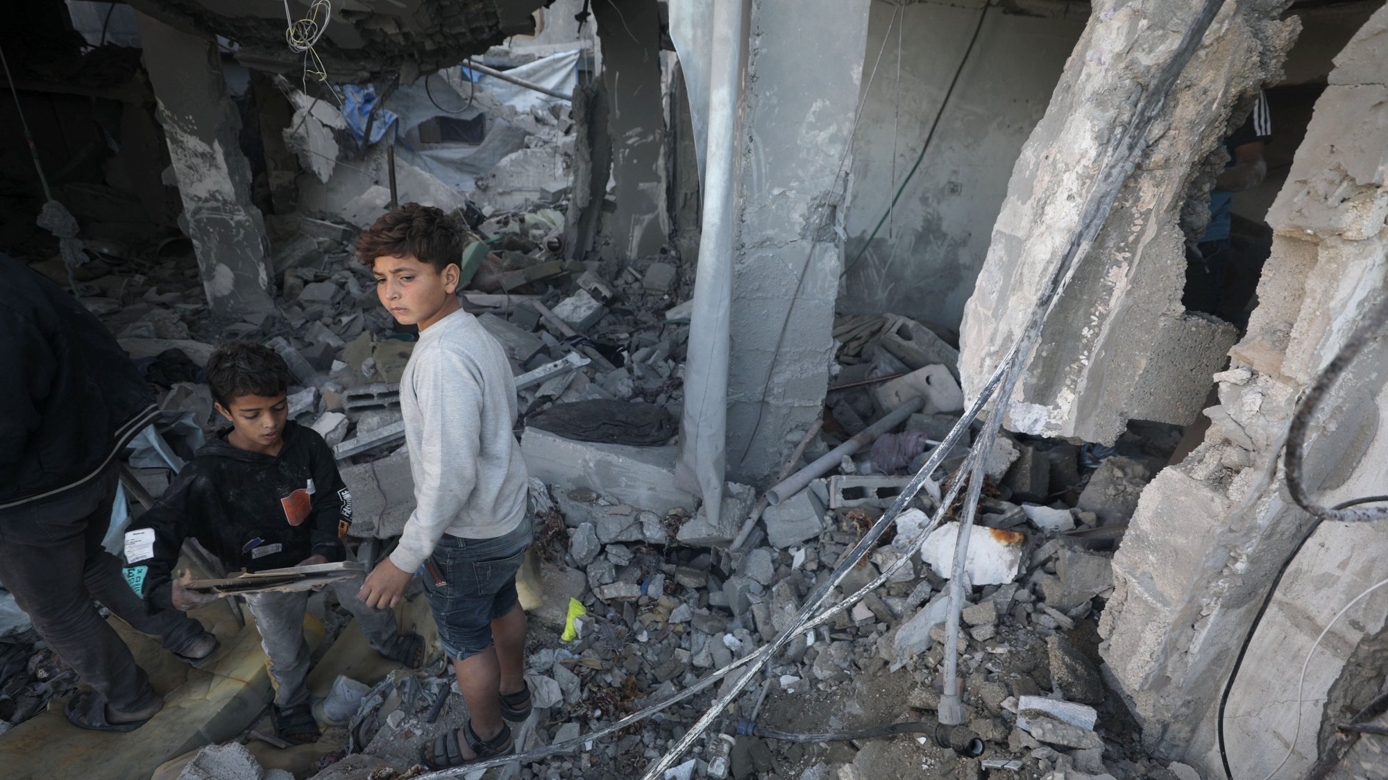 epa11037365 Palestinian children inspect a destroyed house following an Israeli air strike in the east of Deir al Balah town, Gaza Strip, 19 December 2023. More than 60 members of two families were killed after an Israeli airstrike, the Palestinian Civil Defense said. Israeli forces resumed military strikes on Gaza after a week-long truce expired on 01 December. More than 15,000 Palestinians and at least 1,200 Israelis have been killed, according to the Gaza Government media office and the Israel Defense Forces (IDF), since Hamas militants launched an attack against Israel from the Gaza Strip on 07 October, and the Israeli operations in Gaza and the West Bank which followed it.  EPA/MOHAMMED SABER