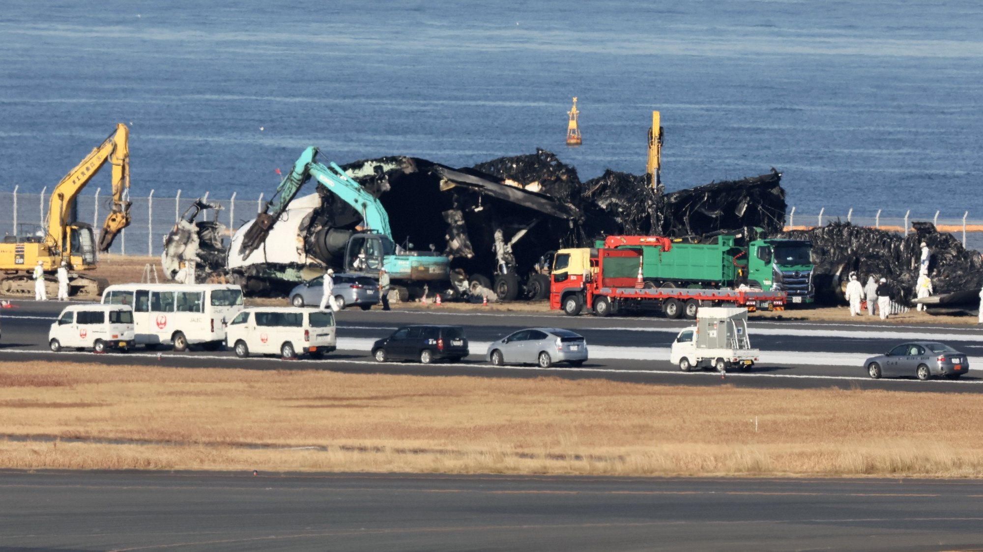 epa11058376 Workers start to remove wreckage following the crash of a Japan Airlines passenger plane with a Japan Coast Guard plane at Haneda Airport in Tokyo, Japan, 05 January 2024. The passenger plane carrying 367 passengers and 12 crew crashed with a Japan Coast Guard plane for transporting relief supplies for the earthquake hit areas. All passengers and crew on board the passenger plane evacuated safely. Tokyo Metropolitan Police confirmed five of six crew on board the Japan Coast Guard plane were dead. Japan Airlines announced on 03 January that the JAL aircraft recognized the controller&#039;s permission to land, read it back, and performed the landing operation. It appears that the Japan Coast Guard plane was already on the runway when it attempted to land, and the Japan Transport Safety Board and the Metropolitan Police Department are investigating the interaction between the controller and the two planes in detail to determine the cause of the accident.  EPA/JIJI PRESS JAPAN OUT EDITORIAL USE ONLY