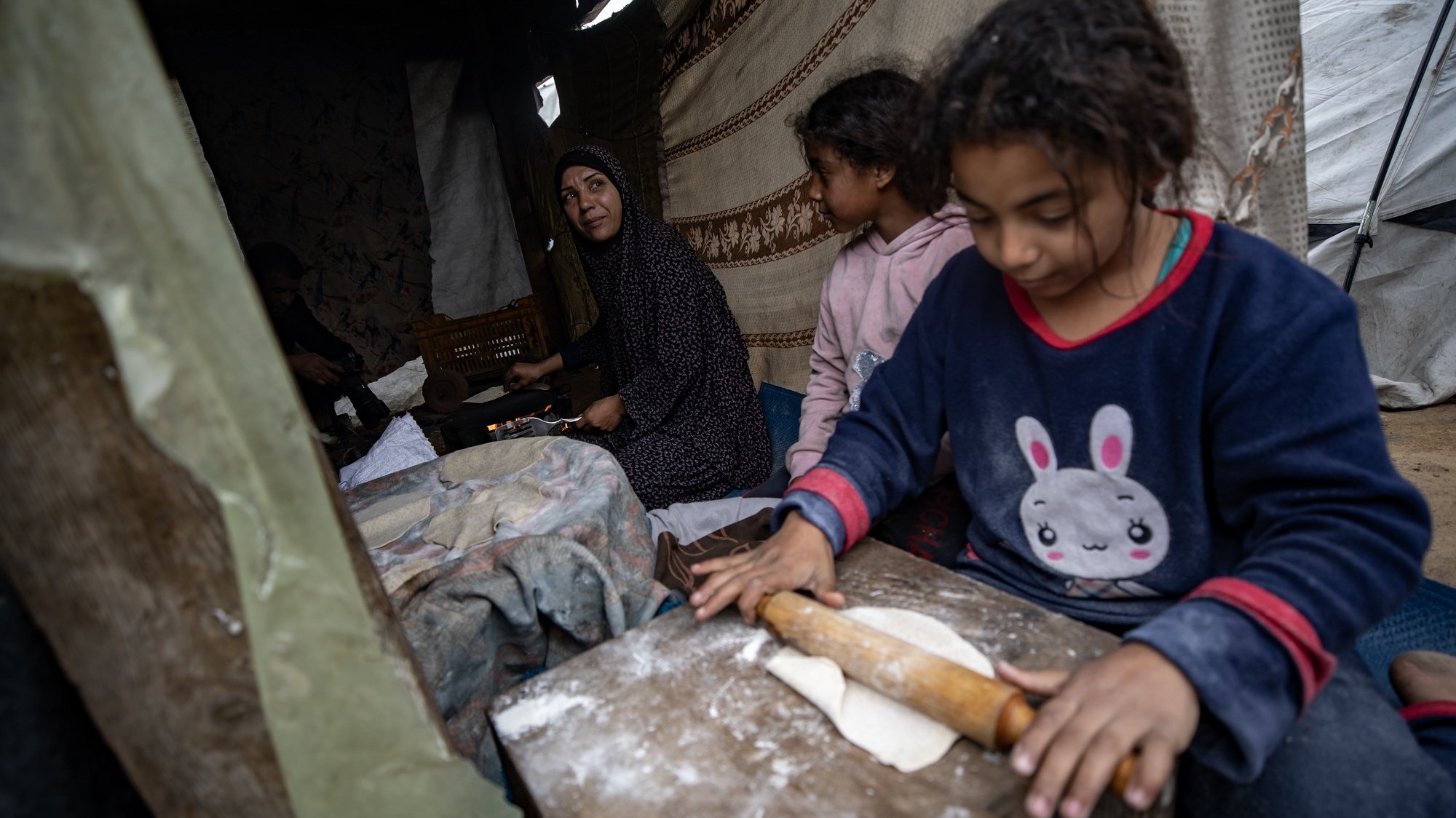 epa11163574 A Palestinian family makes bread in their tent in the Rafah camp, southern Gaza Strip, 18 February 2024. Since 07 October 2023, up to 1.9 million people, or more than 85 percent of the population, have been displaced throughout the Gaza Strip, some more than once, according to the United Nations Relief and Works Agency for Palestine Refugees in the Near East (UNRWA), which added that most civilians in Gaza are in &#039;desperate need of humanitarian assistance and protection&#039;.  EPA/HAITHAM IMAD