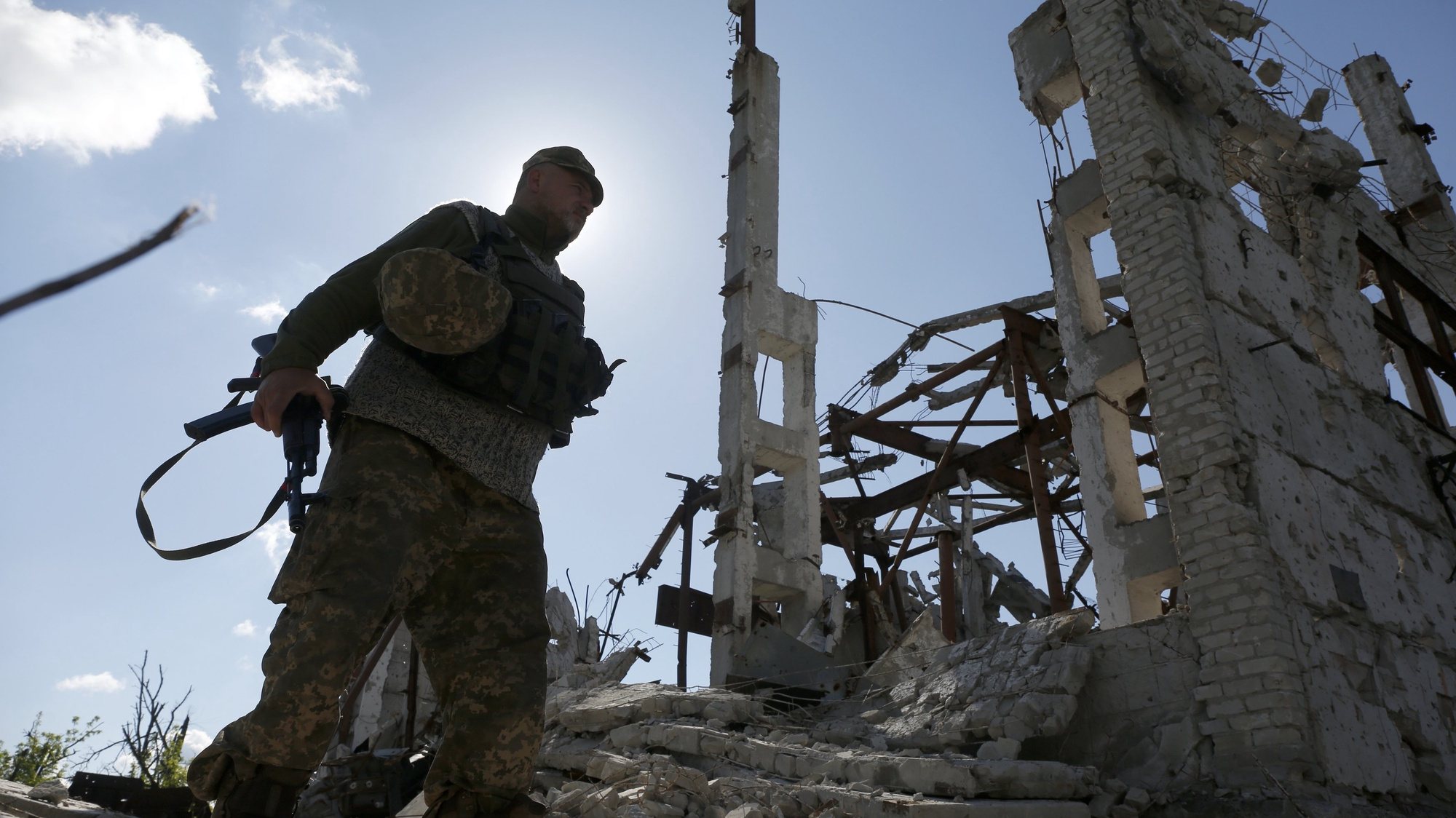 epa05957672 An Ukrainian soldier walks next to a damaged building of the Butovka Coal Mine, after shelling in Donetsk area, Ukraine, 11 May 2017. The number of people wishing to get a biometric passport of a citizen of Ukraine has increased sharply on the territories of the self-proclaimed Donetsk and Luhansk Peoples Republics controlled by pro-Russia rebels, as local media report. The Council of the European Union adopted on 11 May 2017 a regulation on visa liberalization for Ukrainian citizens travelling to the EU for a period of stay of 90 days in any 180-day period.  EPA/VALERI KVIT