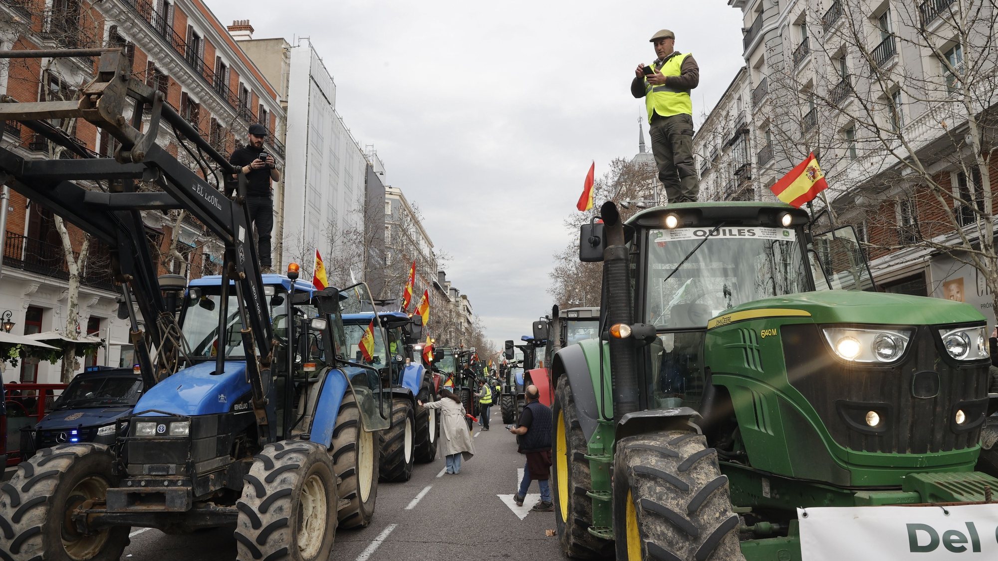 epa11170030 Spanish farmers block the street with their tractors during a protest in downtown Madrid, Spain, 21 February 2024. After two weeks of protests, about 500 tractors and agricultural vehicles are expected to surround the capital and march towards the Ministry of Agriculture in downtown Madrid.  EPA/JP GANDUL