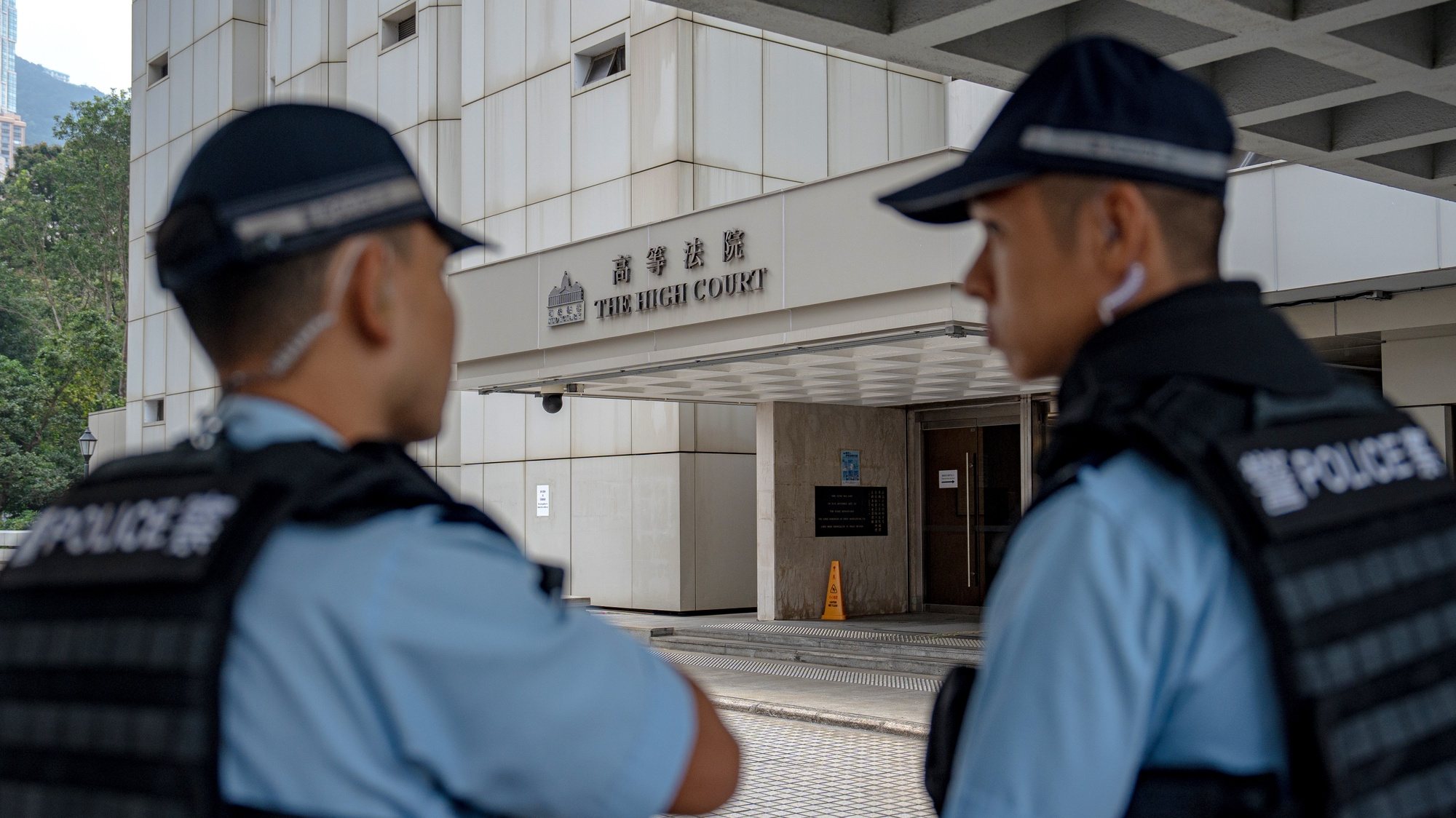 epa11036742 Police officers stand guard outside the High Court building in Hong Kong, China, 19 December 2023. The Court hears today a petition against the refusal to ban the song Glory to Hong Kong.  EPA/LEUNG MAN HEI
