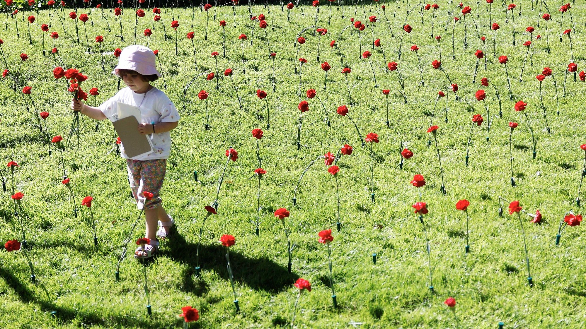 Uma criança brinca nos jardins do Palácio de São Bento, durante as comemorações do 49.º aniversário do 25 de Abril na residência oficial do primeiro-ministro, em Lisboa, 25 de abril de 2023. ANTÓNIO PEDRO SANTOS/LUSA