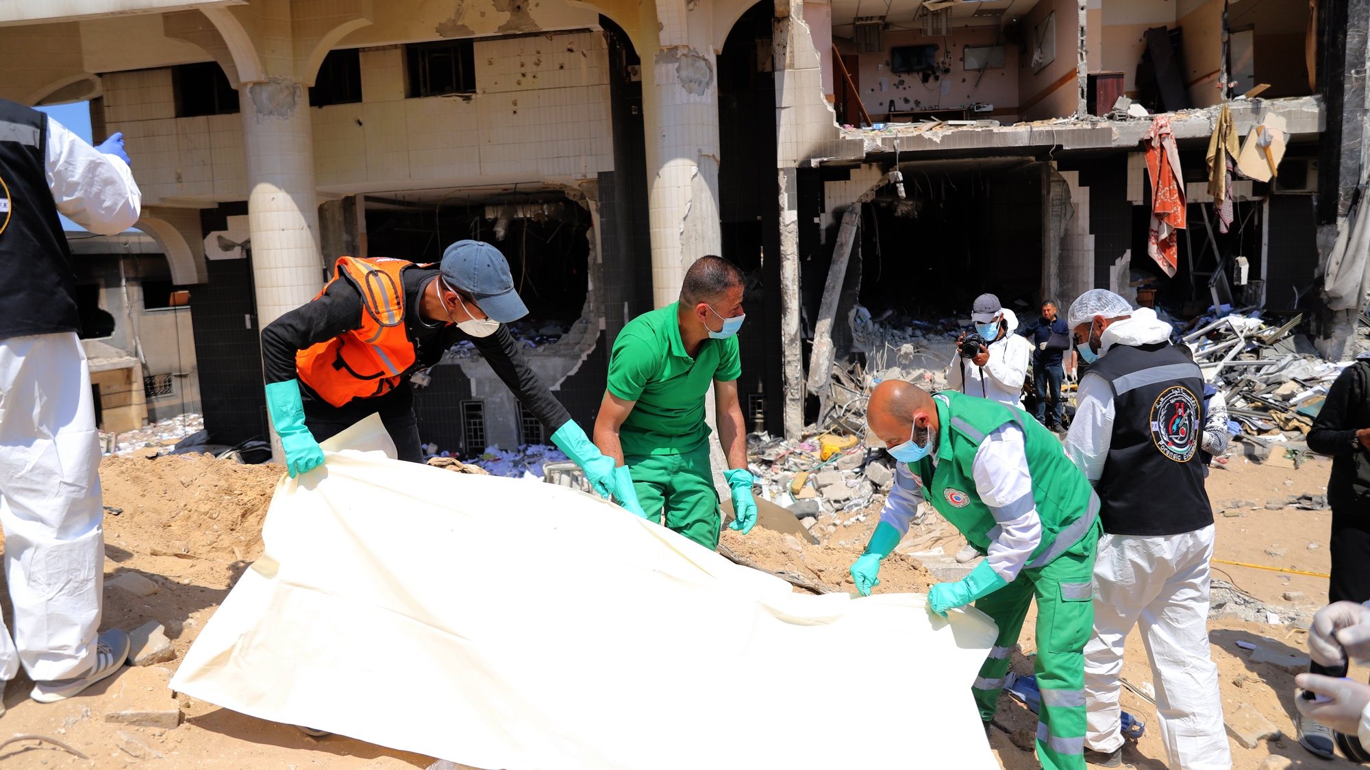 epa11265682 Crew members from the Palestinian ministries of health, justice, and interior examine a body recovered among the rubble after the Israeli army had left the Al-Shifa Medical Hospital Complex in Gaza City, 08 April 2024. According to the Israeli army spokesperson, approximately 500 suspects affiliated with Hamas were apprehended and 200 were eliminated. More than 33,000 Palestinians and over 1,450 Israelis have been killed, according to the Palestinian Health Ministry and the Israel Defense Forces (IDF), since Hamas militants launched an attack against Israel from the Gaza Strip on 07 October 2023, and the Israeli operations in Gaza and the West Bank which followed it.  EPA/MOHAMED HAJJAR