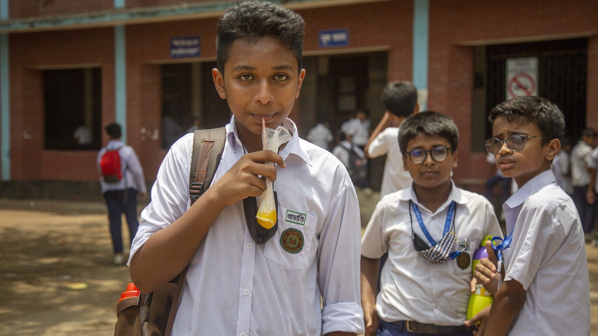 epa09952275 School children drink lemon juice from a street vendor during a hot summer day in Dhaka, Bangladesh, 17 May 2022. According to the Bangladesh Meteorological Department (MET) office report, a mild heat wave sweeping over Bangladesh.  EPA/MONIRUL ALAM