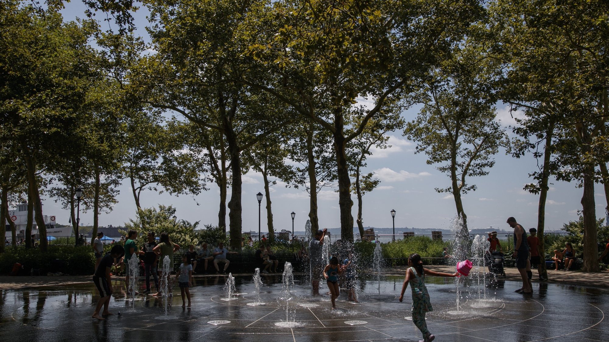 epa10774229 Children play in a water fountain during a heat wave at Battery Park in New York, New York USA, 28 July 2023. The East Coast is experiencing temperatures in the high 90&#039;s and a heat index of over 100 degrees Fahrenheit.  EPA/SARAH YENESEL 23441