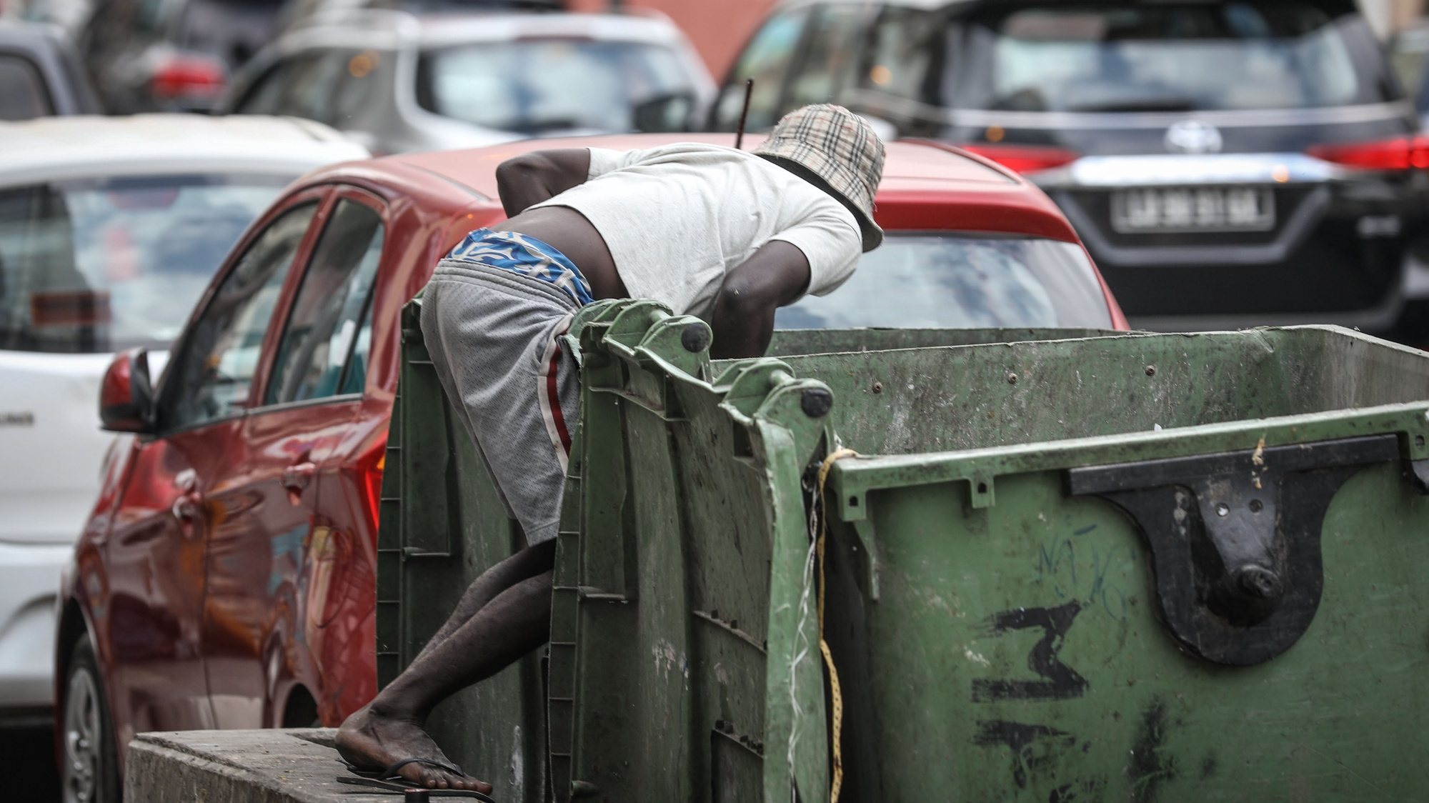 Uma criança cata o lixo de um contentor numa rua em Luanda, Angola, 03 de junho de 2024. Engraxar sapatos ou catar lixo em contentores são atividades onde estão mergulhadas centenas de “candengues” (crianças) em idade escolar que deambulam em pequenos grupos pelas ruas da capital angolana. (ACOMPANHA TEXTO DA LUSA DO DIA 10 DE JUNHO DE 2024). AMPE ROGÉRIO/LUSA