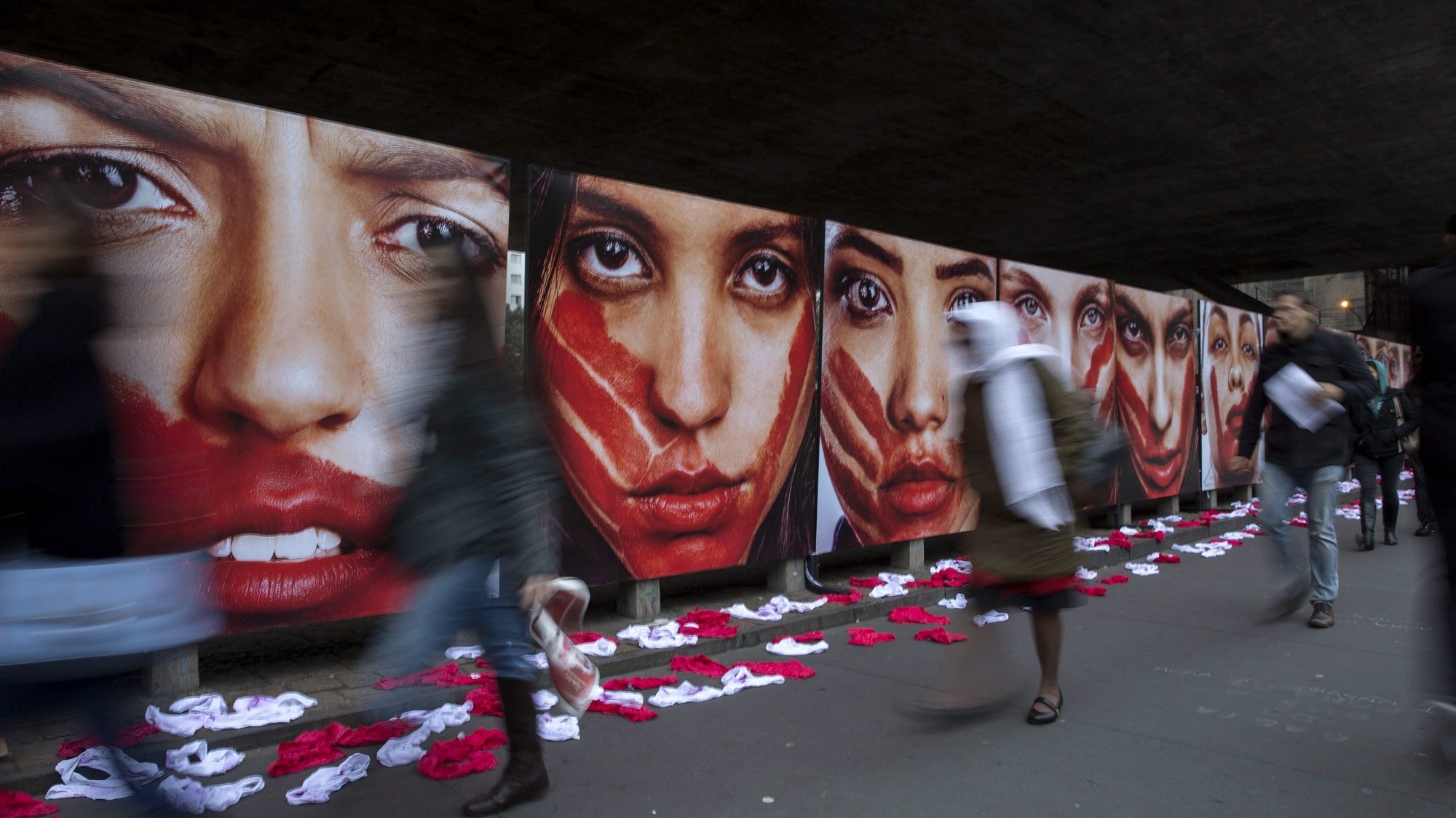 epa05354835 A group of people walk next to an installation by NGO Rio de Paz that shows pictures of models representing women victims of sexual attacks and 420 underpants that represent the 420 Brazilian women raped in the country every 72 hours, outside the Sao Paulo Arts Museum in Sao Paulo, Brazil, 10 June 2016.  EPA/SEBASTIAO MOREIRA