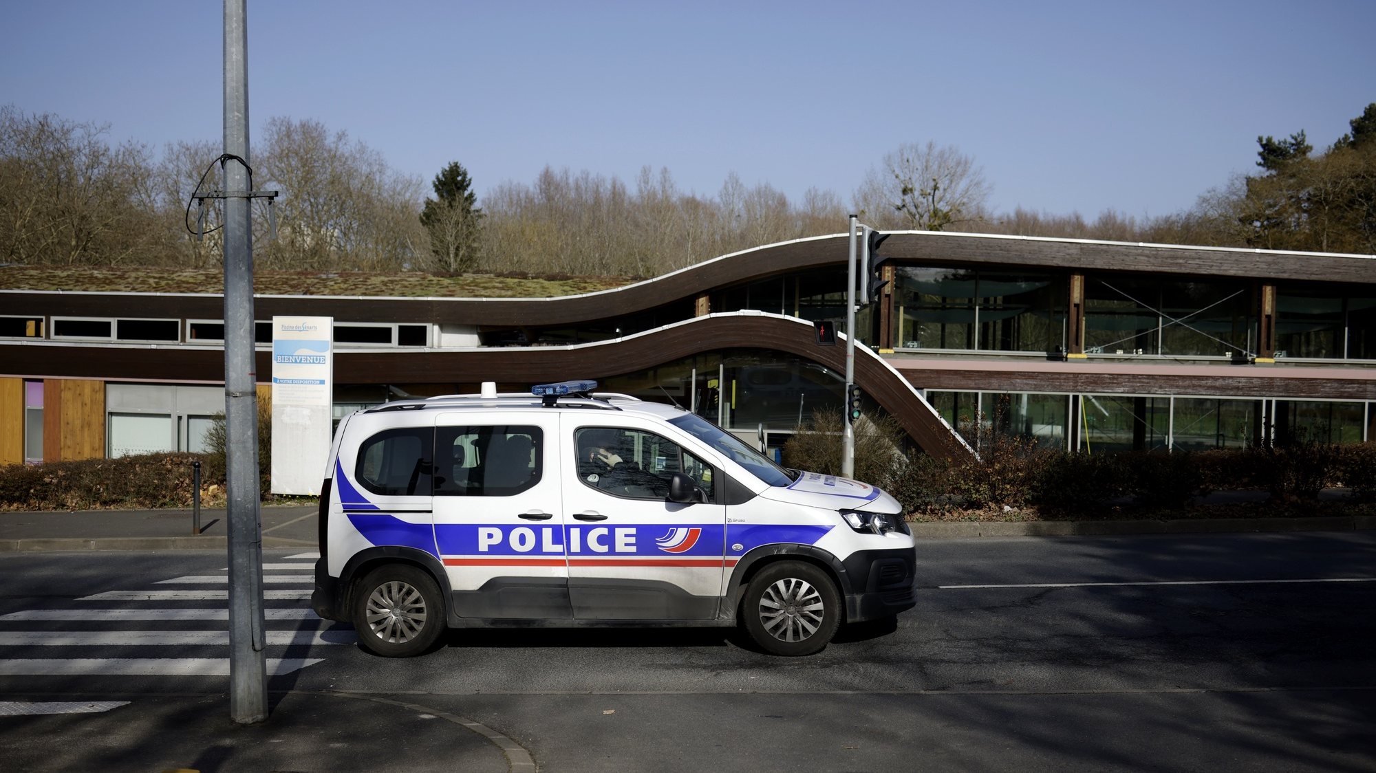 epa09033387 A police car drives by the public swimming pool in the aftermath of the death of a 14-year-old teenager in a brawl between rival gangs on 23 February 2021, in Boussy-Saint-Antoine, south of Paris, France, 24 February 2021. A young schoolgirl also died following clashes between rival gangs on 22 February in Saint-Cheron. French Interior Minister Darmanin announced that 60 gendarmes in Saint-Cheron and 30 police officers in Boussy-Saint-Antoine will be deployed as reinforcement.  EPA/YOAN VALAT