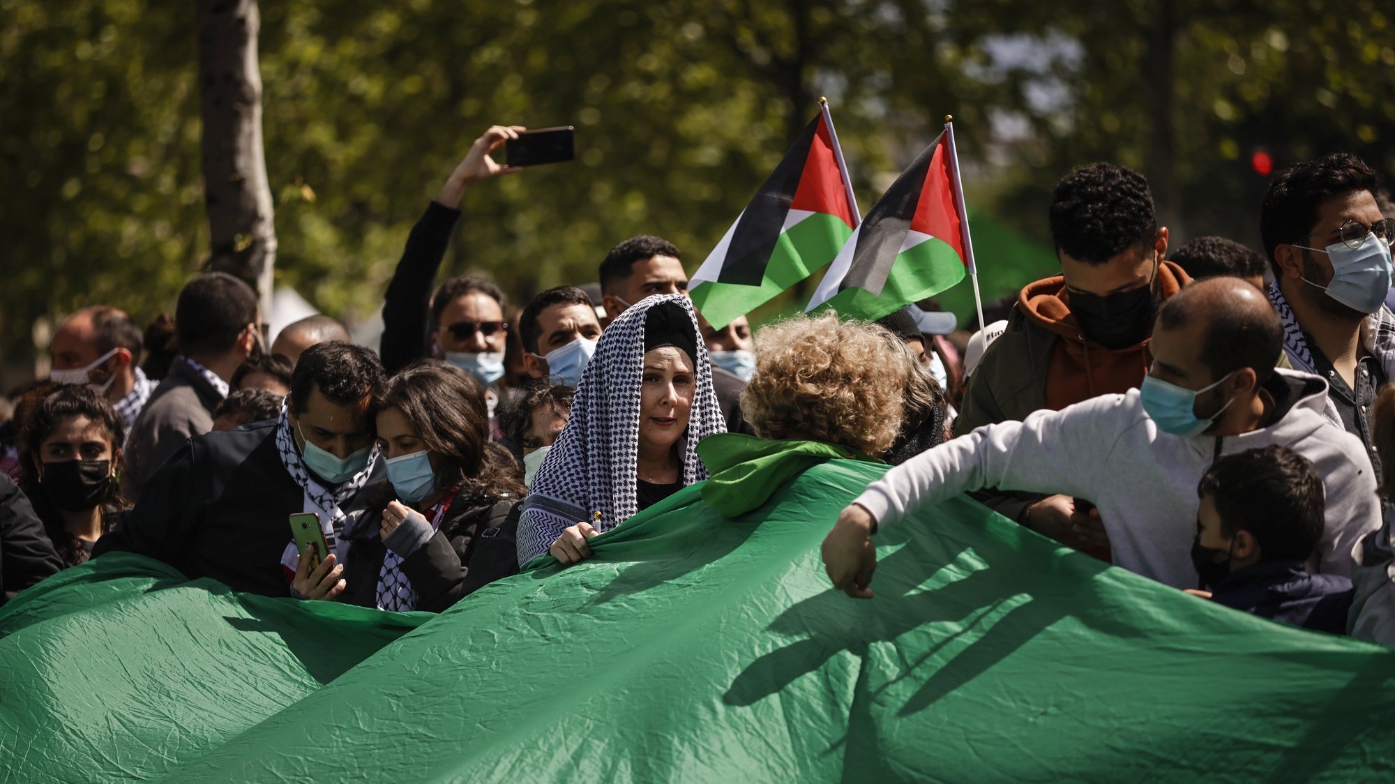 epa09220251 People wave Palestinian flags during a protest against Israel in solidarity with the Palestinian people, in Paris, France, 22 May 2021. Israel and Hamas have announced a cease fire following 11 days of violent confrontations.  EPA/YOAN VALAT