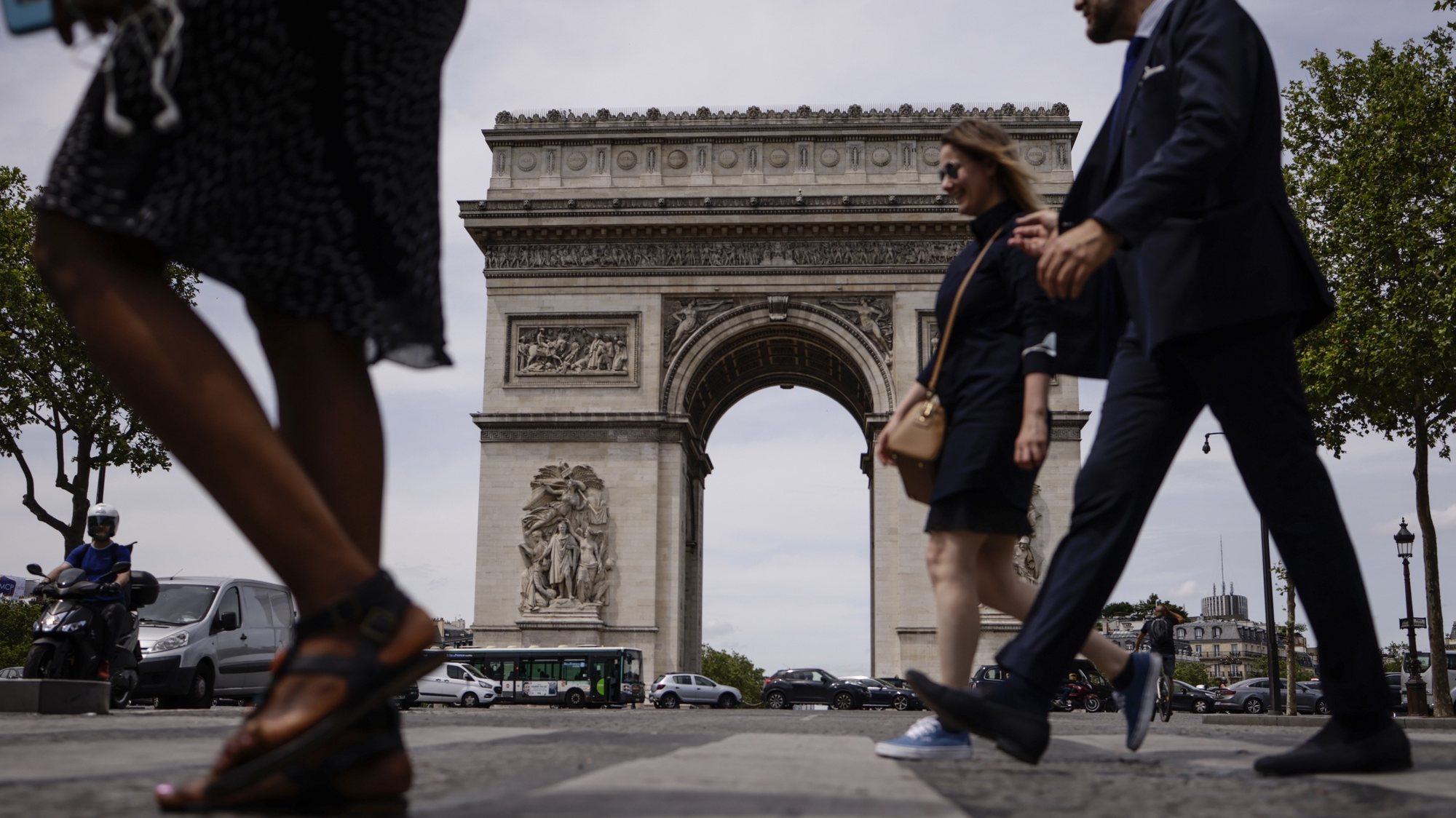 epa09279479 People not wearing protective face masks walk past the Arc of Triomphe in Paris, France, 17 June 2021. France eases some of its coronavirus disease (COVID-19) restrictions starting on 17 June, allowing not to wear a face mask in the streets.  EPA/YOAN VALAT